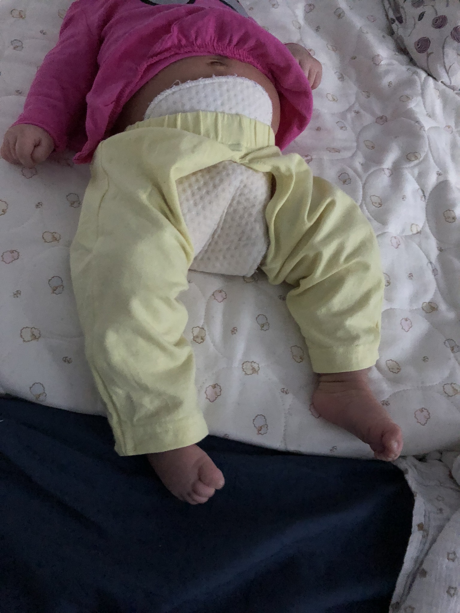 Lying down with a soaker pad gently tucked into the waistband.