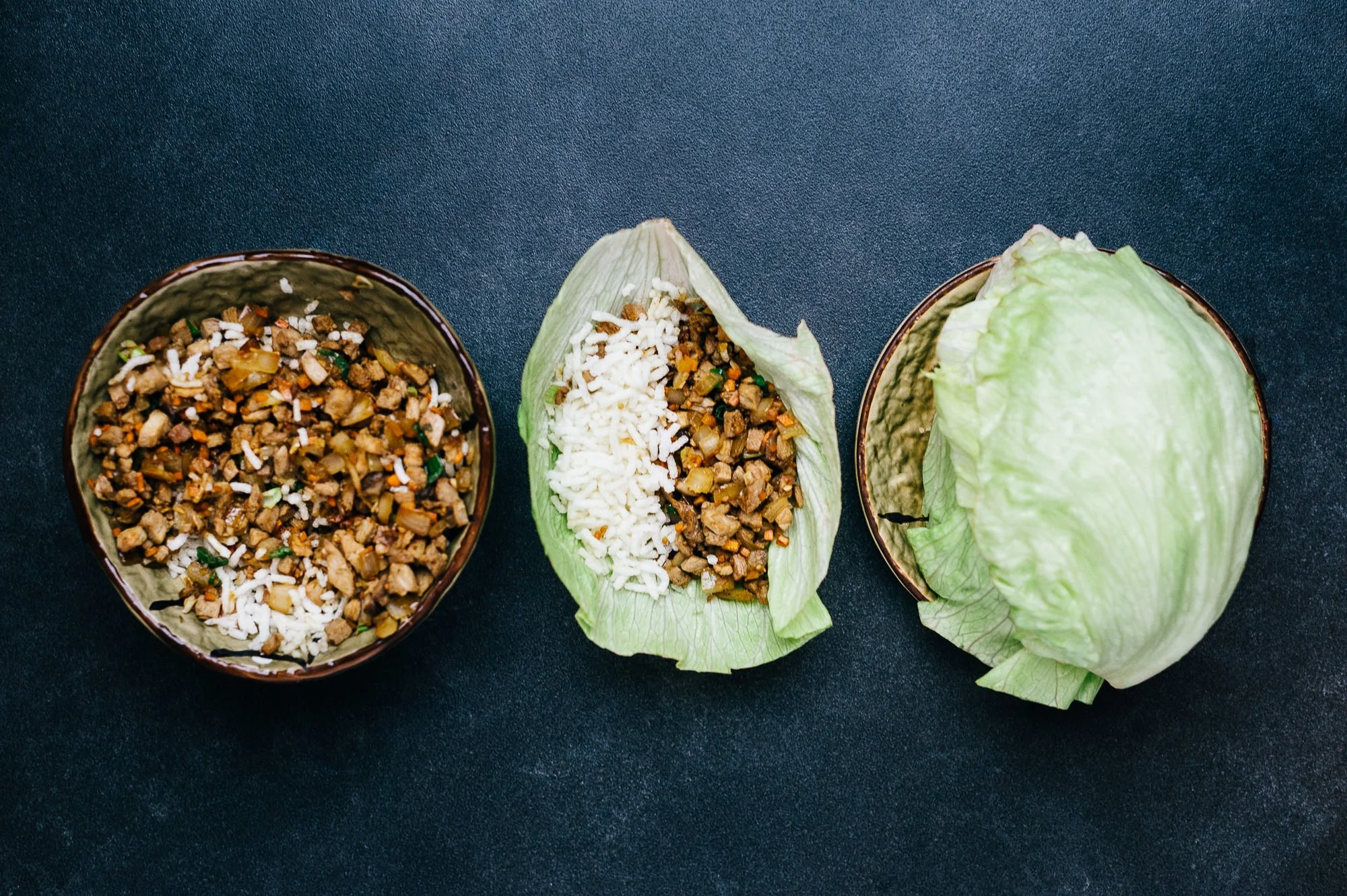 Cabbage leaves and bowls of seasoned ground meat and rice filling for stuffed cabbage rolls