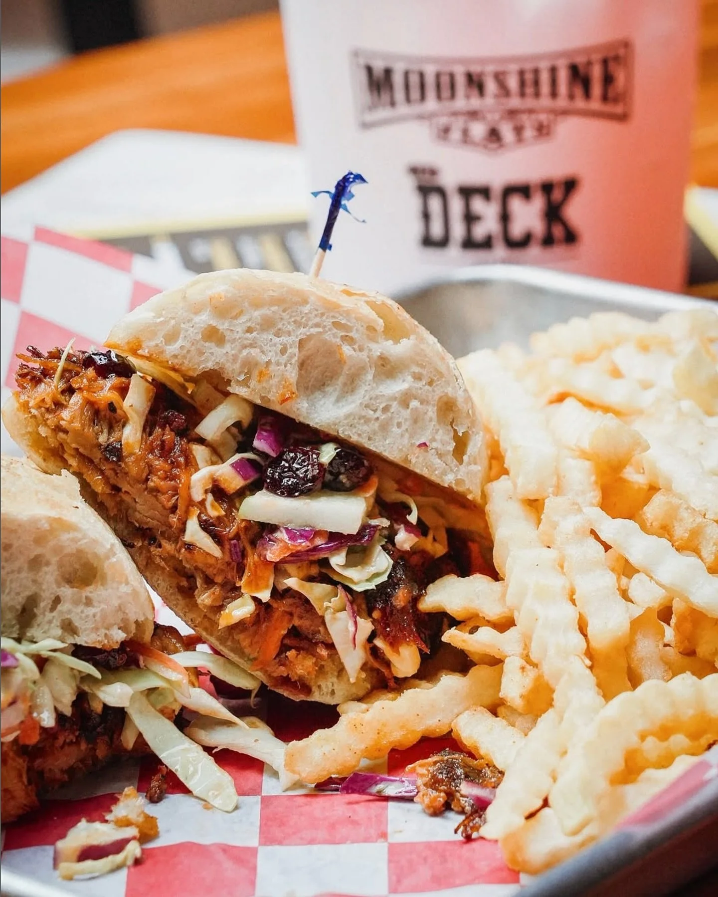 Hungry for a pregame bite? Dig into our pulled pork sandwich&mdash;stacked with BBQ sauce, coleslaw, and crispy onions on a brioche bun. A cocktail bucket on the side optional, but highly recommended.🪣🥤