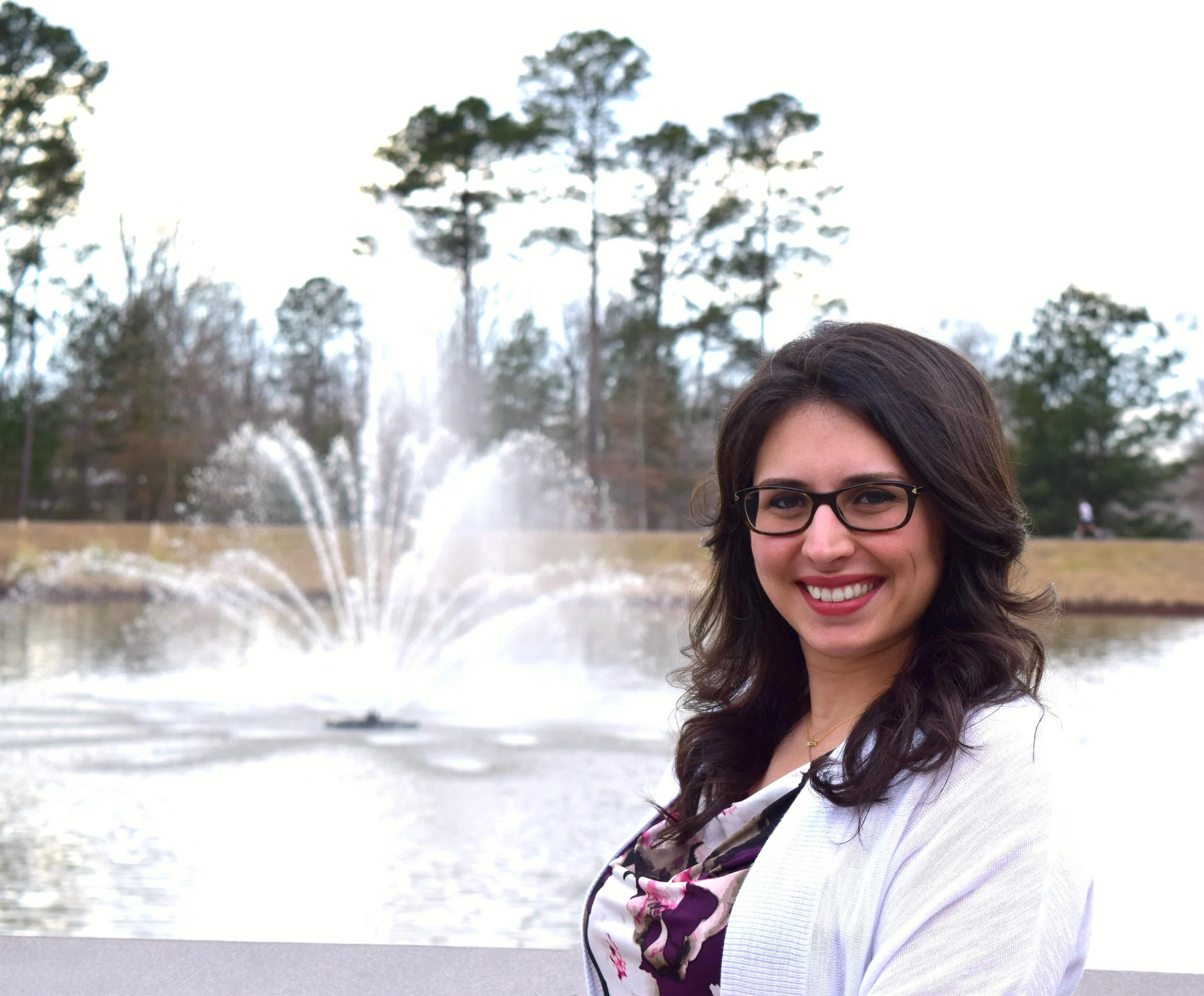Bahar Dunn, LMFT EMDR Trauma Therapist in Jackson, MS standing by fountain in pond