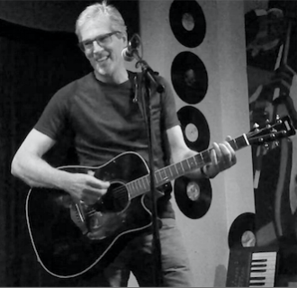 TED MAYNARD Dan Smith is turning me into a guitar player. Dan makes it fun, and he seems to know just what it is I need to keep moving me forward. After just a year of lessons, Dan had me doing open mics around the City and performing at his Solo Performance Workshops in front of other students and friends and family. Dan has created a community among his students, and we enjoy playing at open mics and Dan’s Workshops together. I would never have imagined myself getting as far as I have in such a short time, and I attribute most of that success to Dan. He is adept at sensing what might be holding me back in my guitar playing, physically or emotionally, and then helping me find a way to keep moving forward in my music. I feel enormously fortunate to have Dan as a teacher.