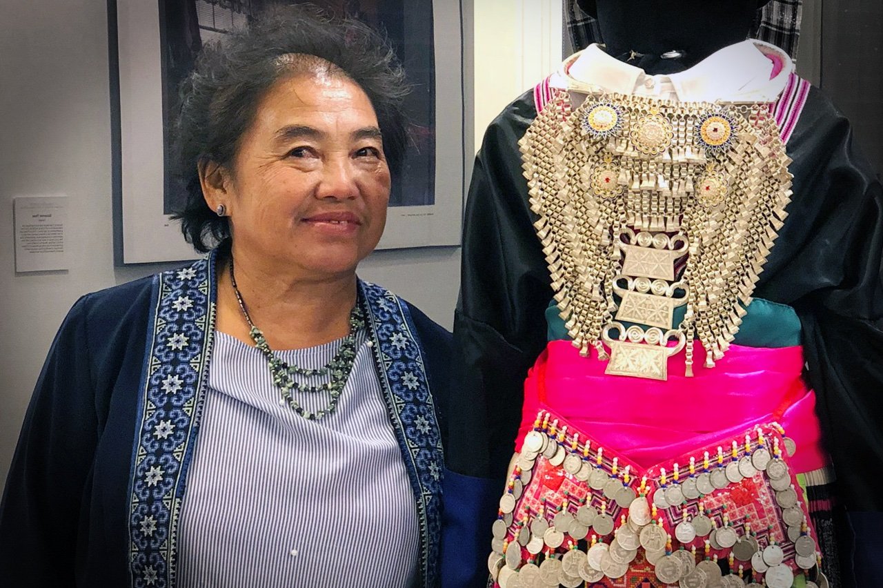 Suzanne Thao next to Hmong New Year's dress.jpeg