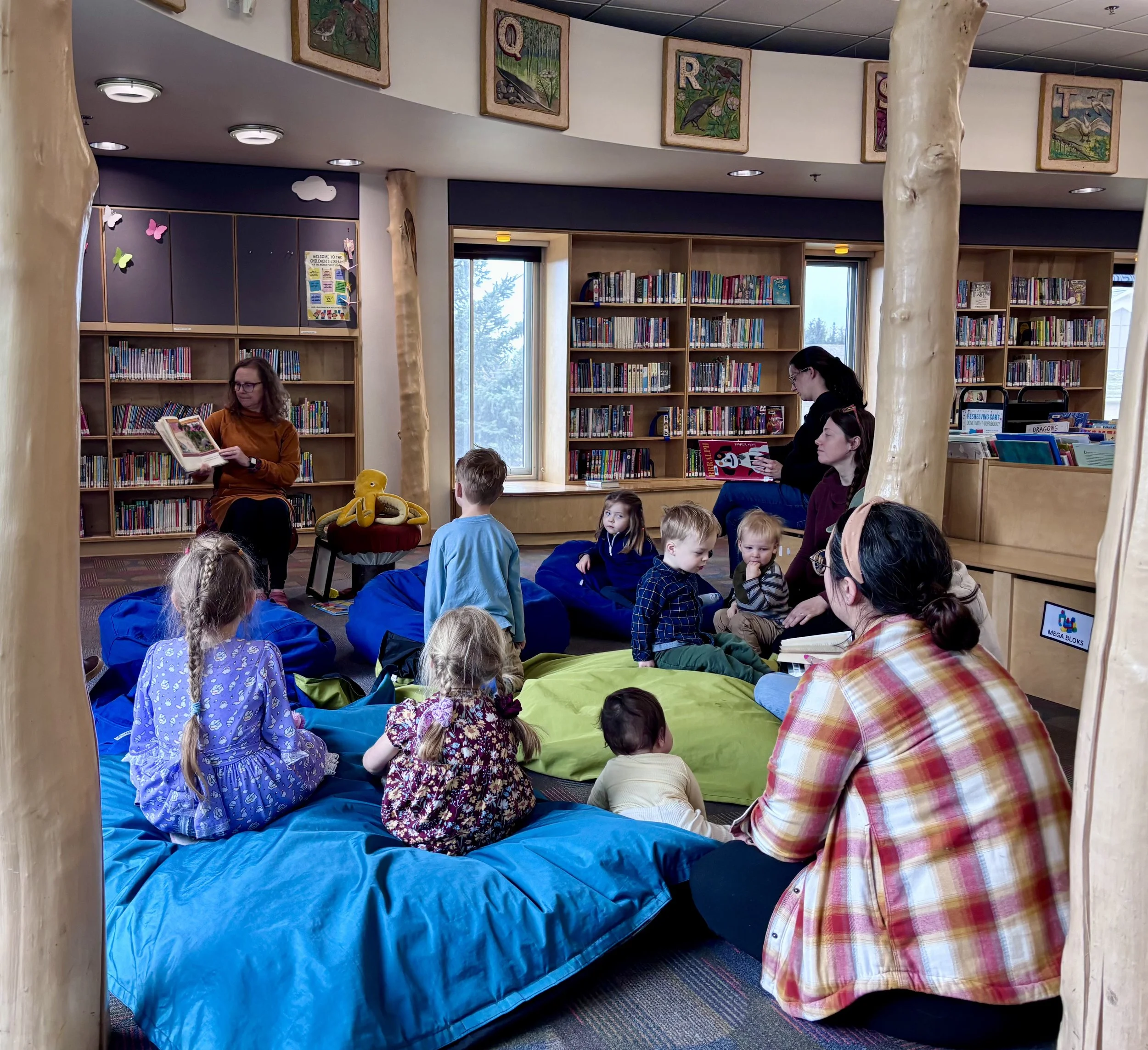 Cinda reads to kids and their adults with trees and pods.jpeg