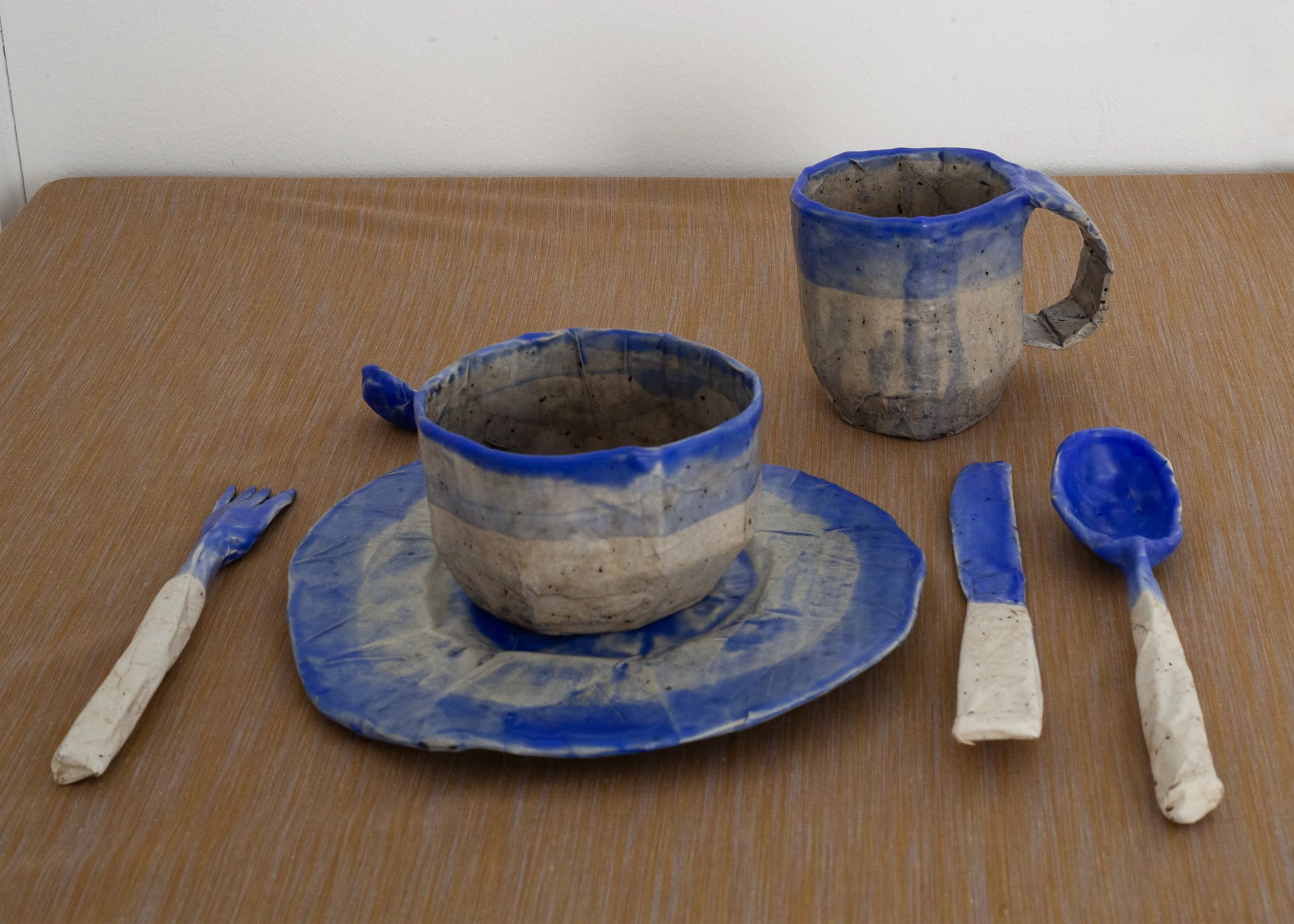   Dishes , 2025, cardboard, papier-mâché, beeswax, ultramarine pigment, dimensions variable 