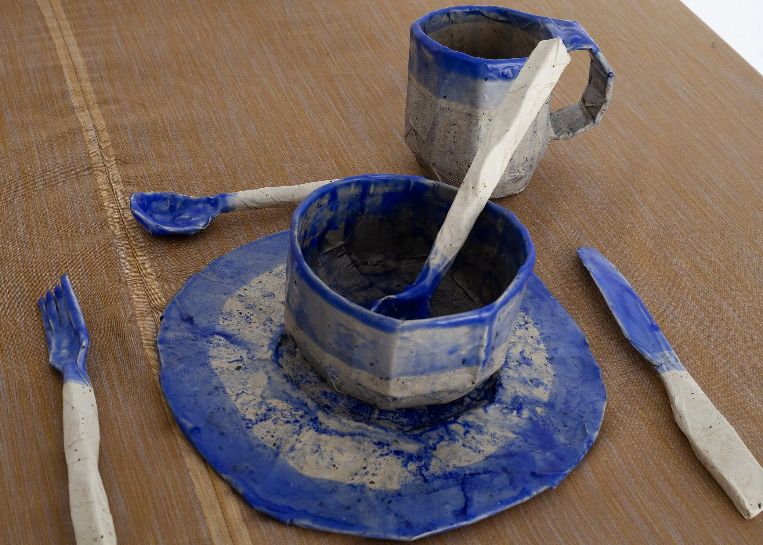   Dishes , 2025, cardboard, papier-mâché, beeswax, ultramarine pigment, dimensions variable 
