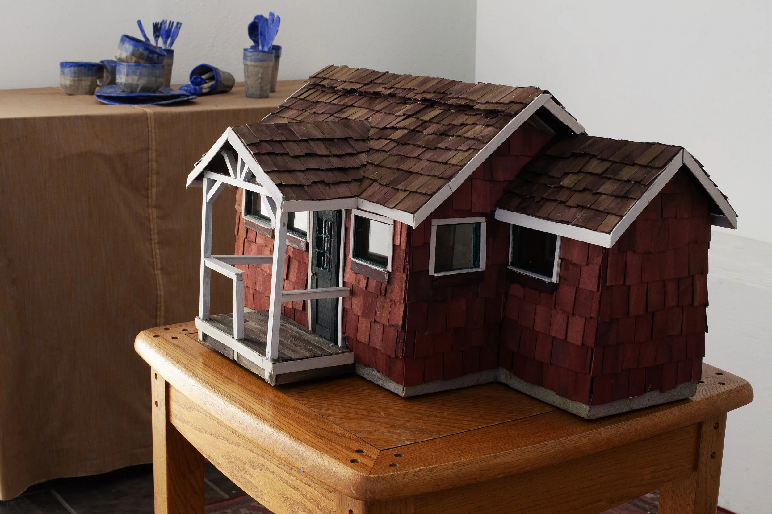   The Long Walk Home  exhibition view   Everyone Is There, Everyone Will Leave at Exactly The Same Time , 2025, cardboard, papier-mâché, wood, dye, acrylic paint, glass, wire, lemongrass, coffee, cloves, audio loop featuring loved ones (living and de