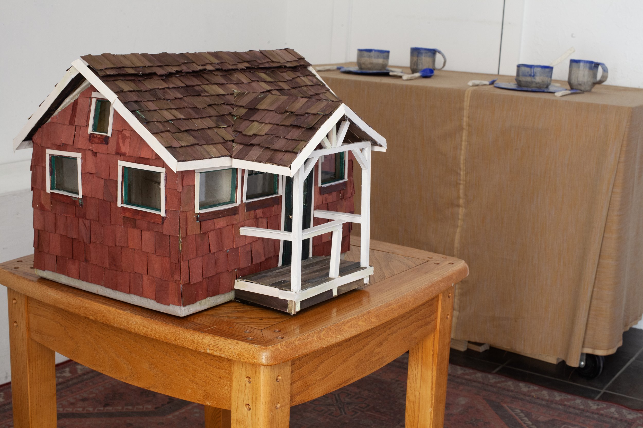   The Long Walk Home  exhibition view   Everyone Is There, Everyone Will Leave at Exactly The Same Time , 2025, cardboard, papier-mâché, wood, dye, acrylic paint, glass, wire, lemongrass, coffee, cloves, audio loop featuring loved ones (living and de