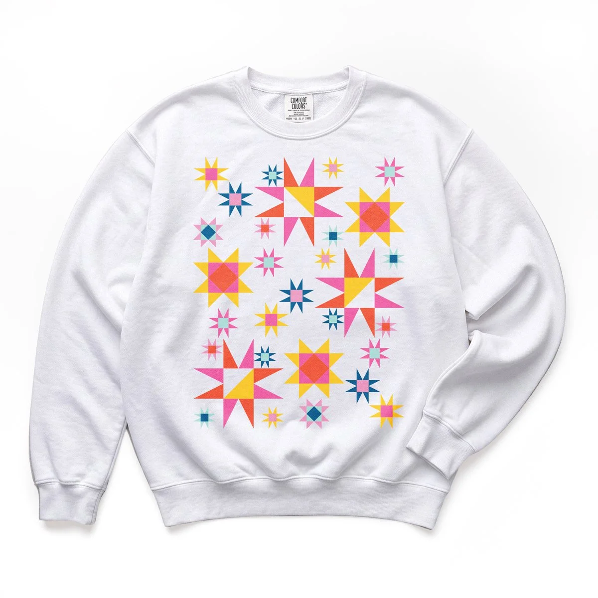 Stardust Shine quilt block sweatshirt by She Makes Joy in White, a Comfort Colors crewneck with scattered pink, red, yellow, and blue star blocks
