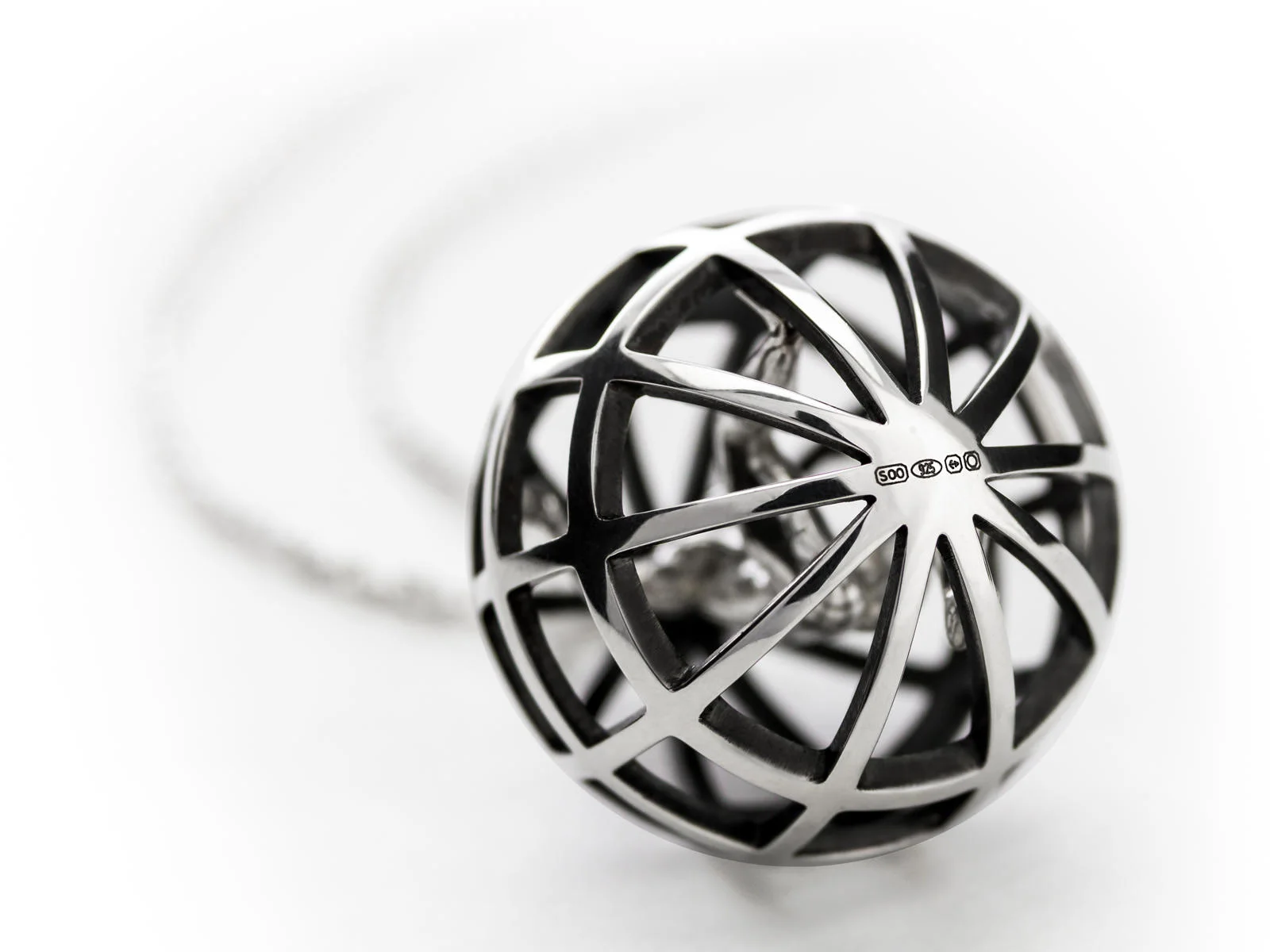 A sterling silver Atlas pendant with the bottom Saxons hallmark visible