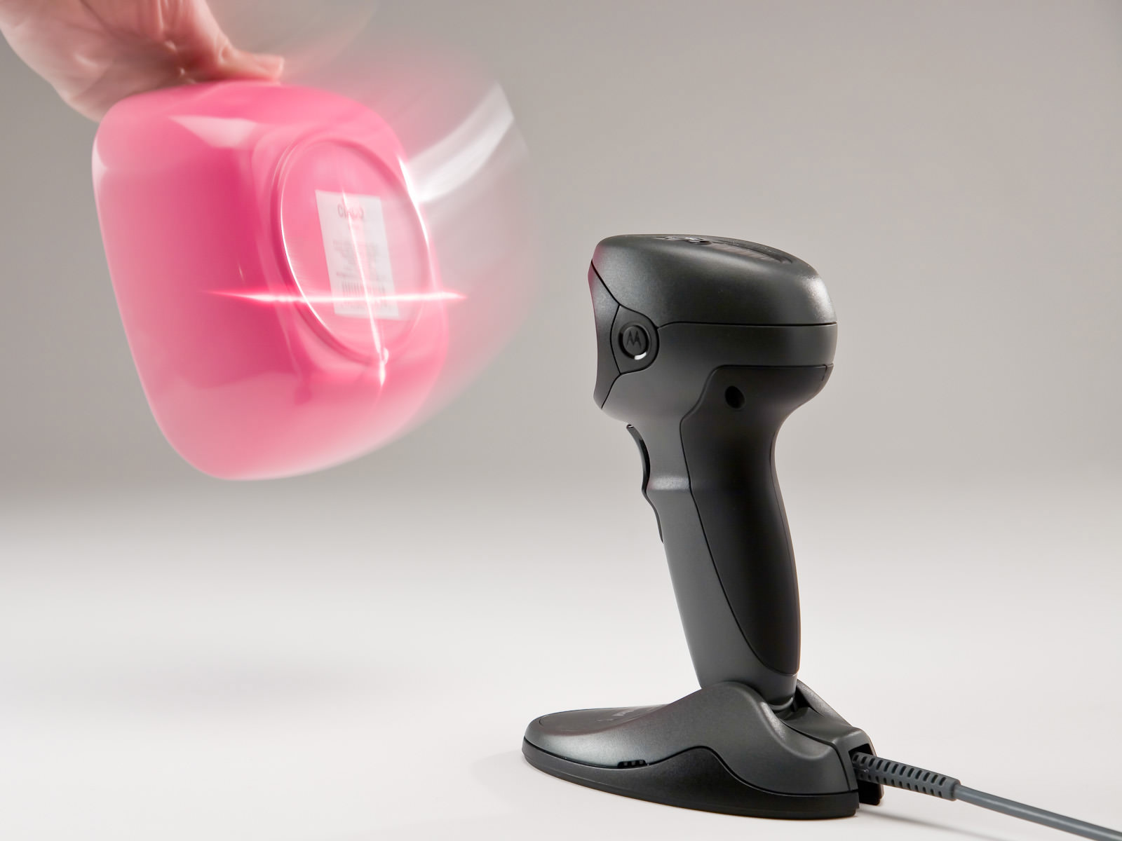A pink container, with motion blur, being passed in front of an actively scanning black DS9808