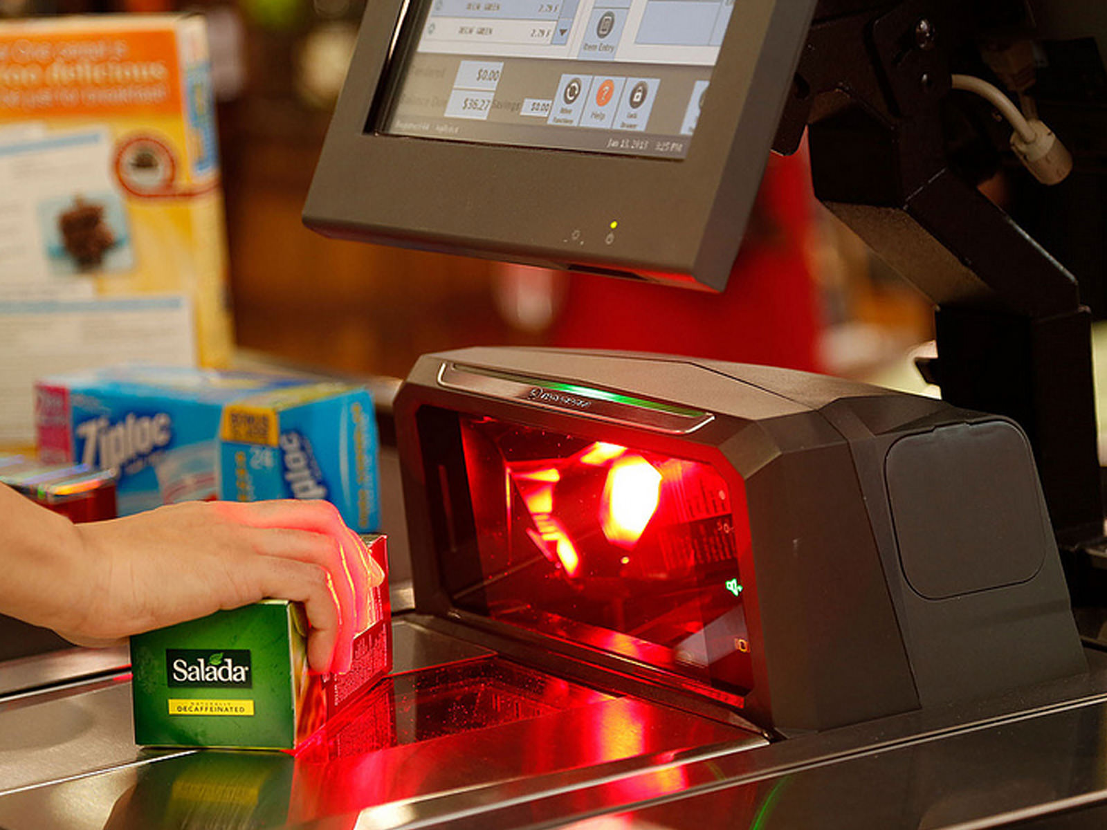 The MP6000 being used in a supermarket setting, with an object being passed in front of the main scan window and lighting up red