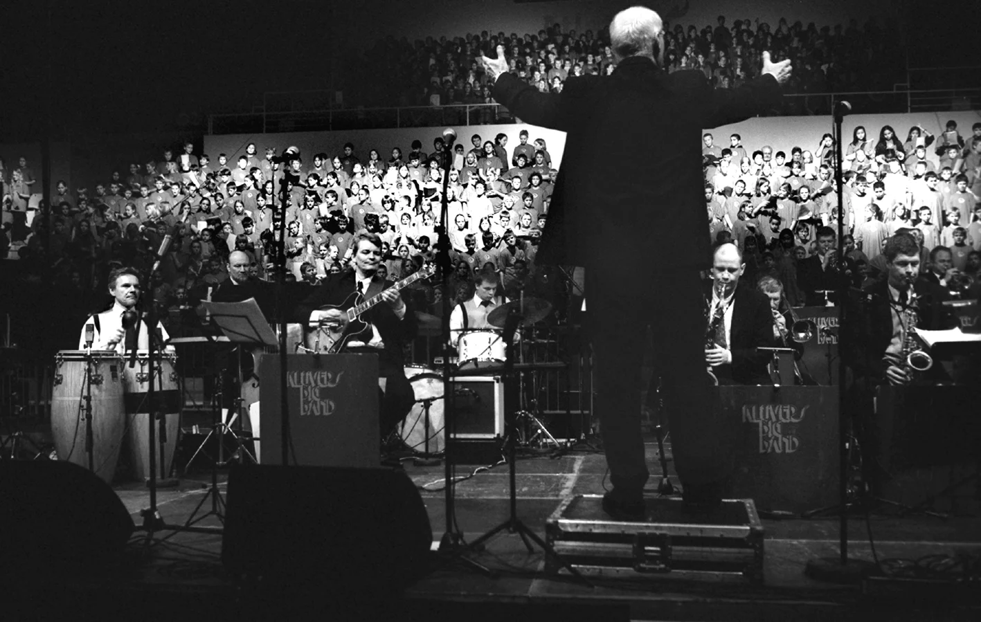 Jens Klüver dirigerer bigband og små 1500 skoleelever under årets kæmpekor i Ceres Arena, 2004.