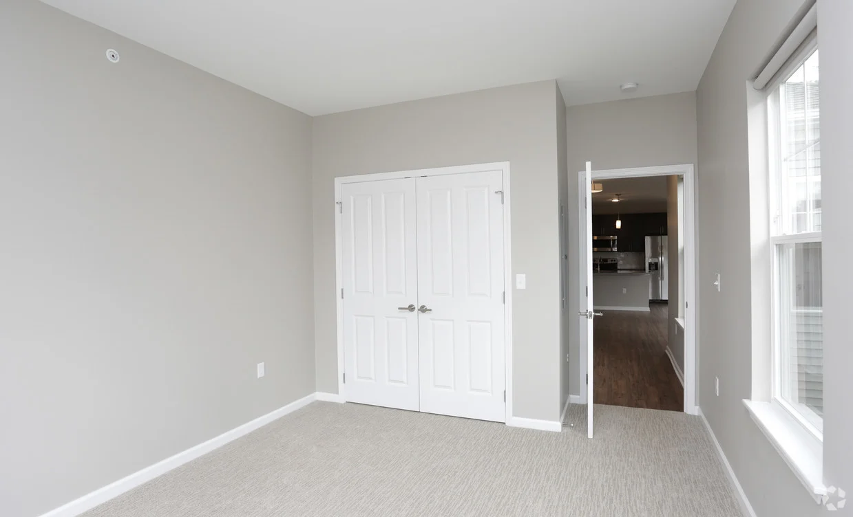 Spacious bedroom with window and double door closet