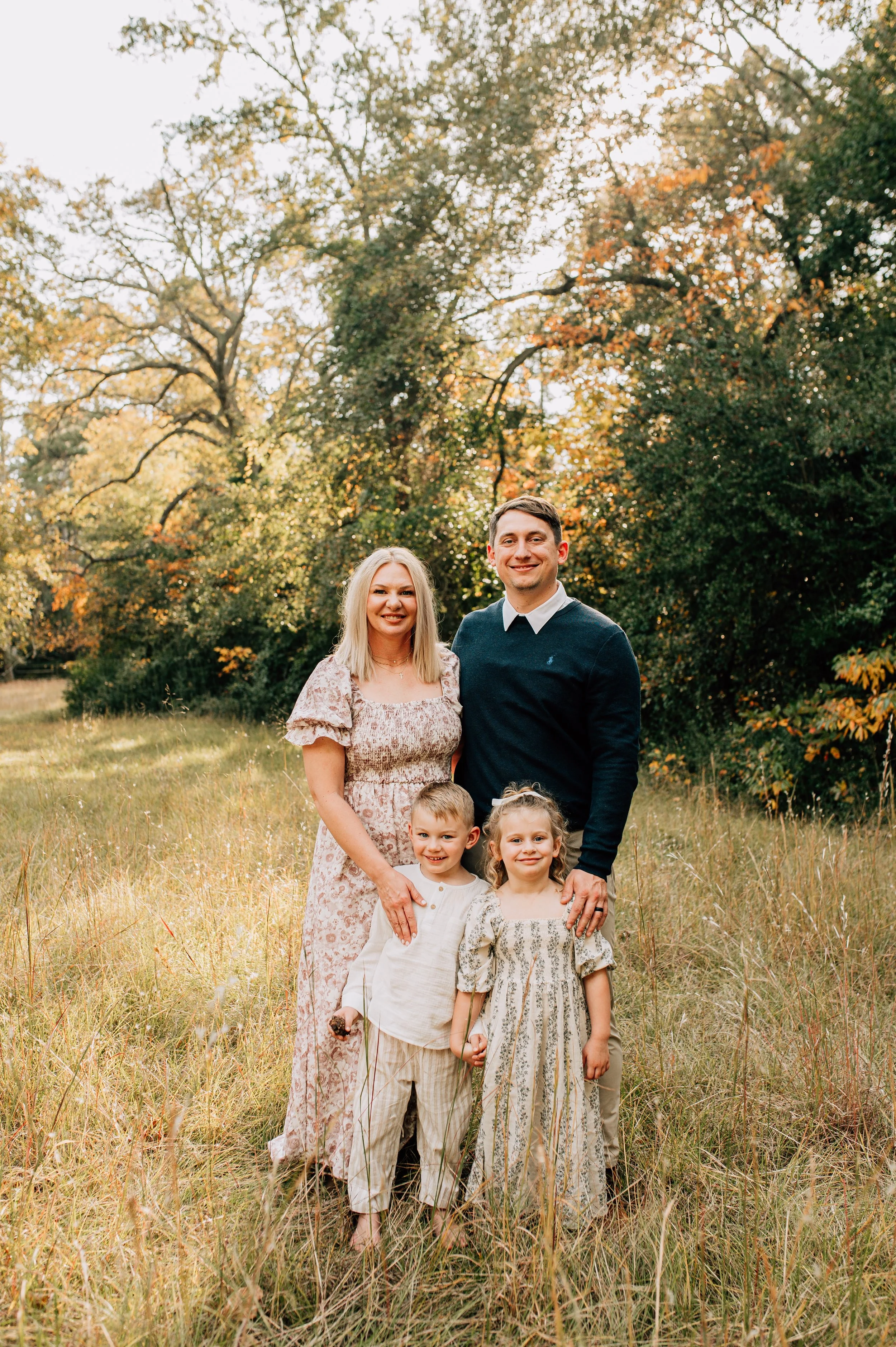 Smiling family of four in a spring field