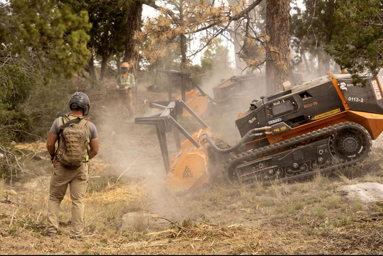 A man operating a remote controlled masticator.