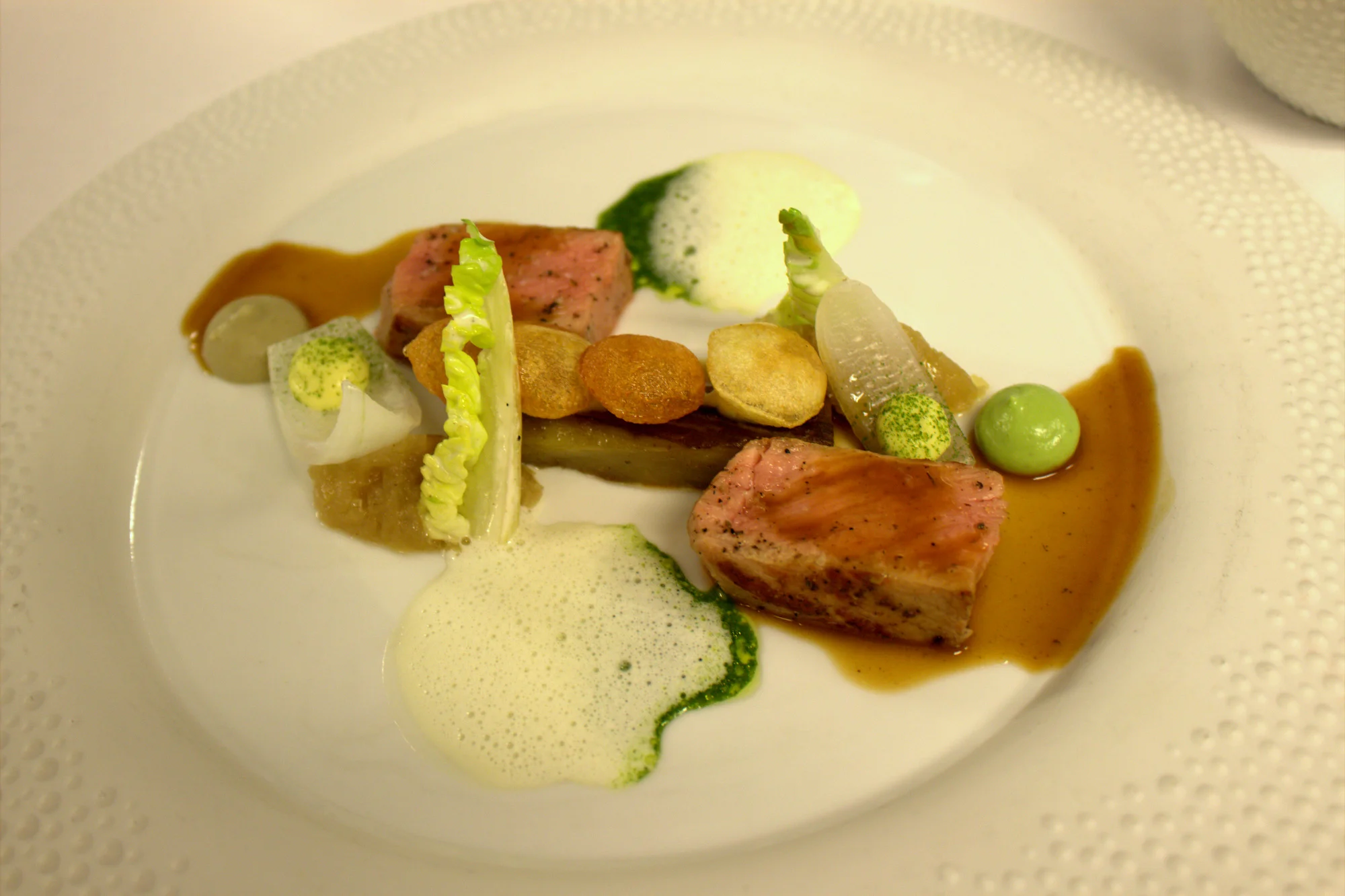 veal dish is served with sweet onion, aubergine, artichoke and a garlic distillation