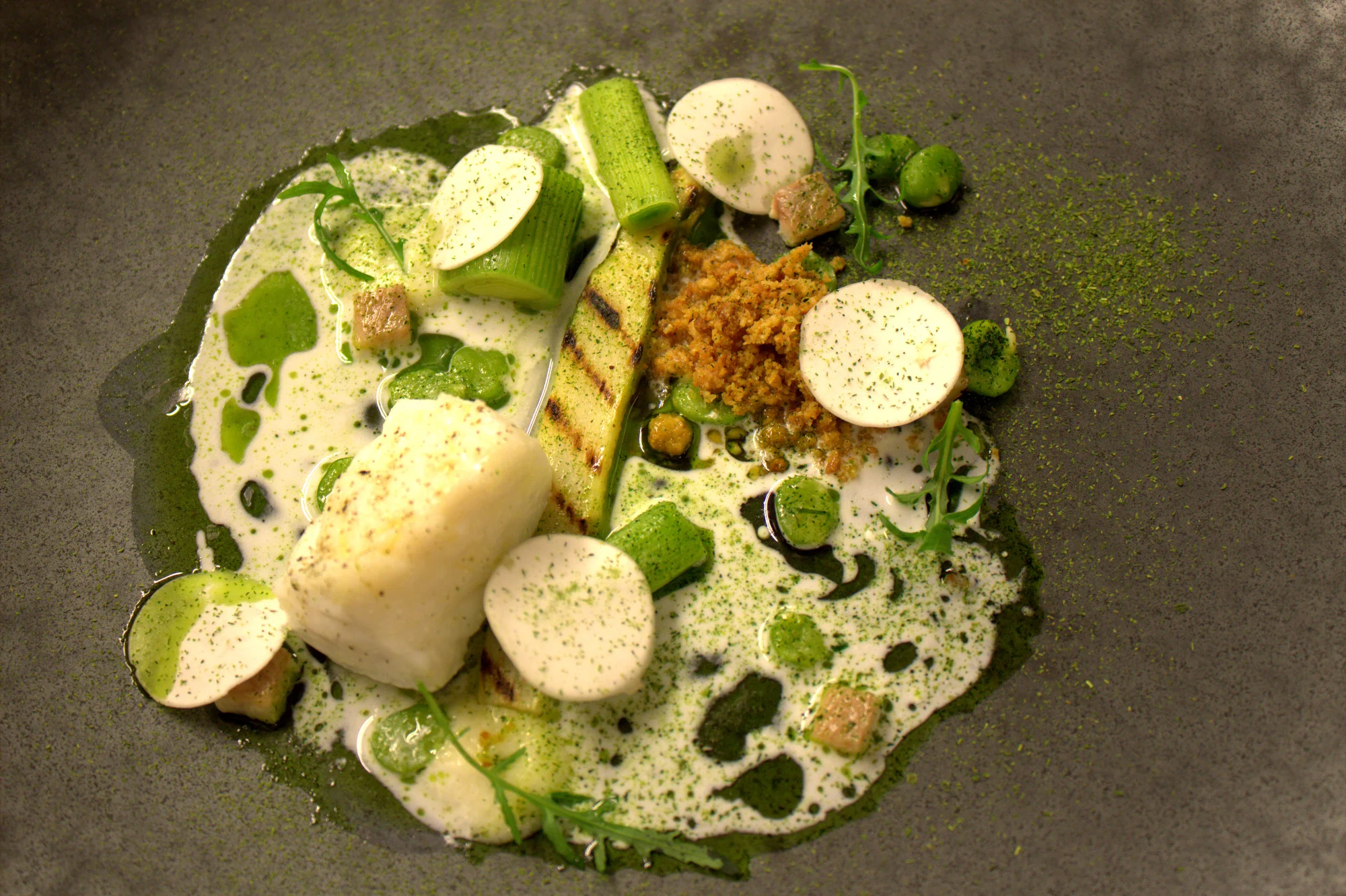 Cod with Parmesan crumble and cream, smoked eels, asparagus, peas, buttermilk and a rocket sauce