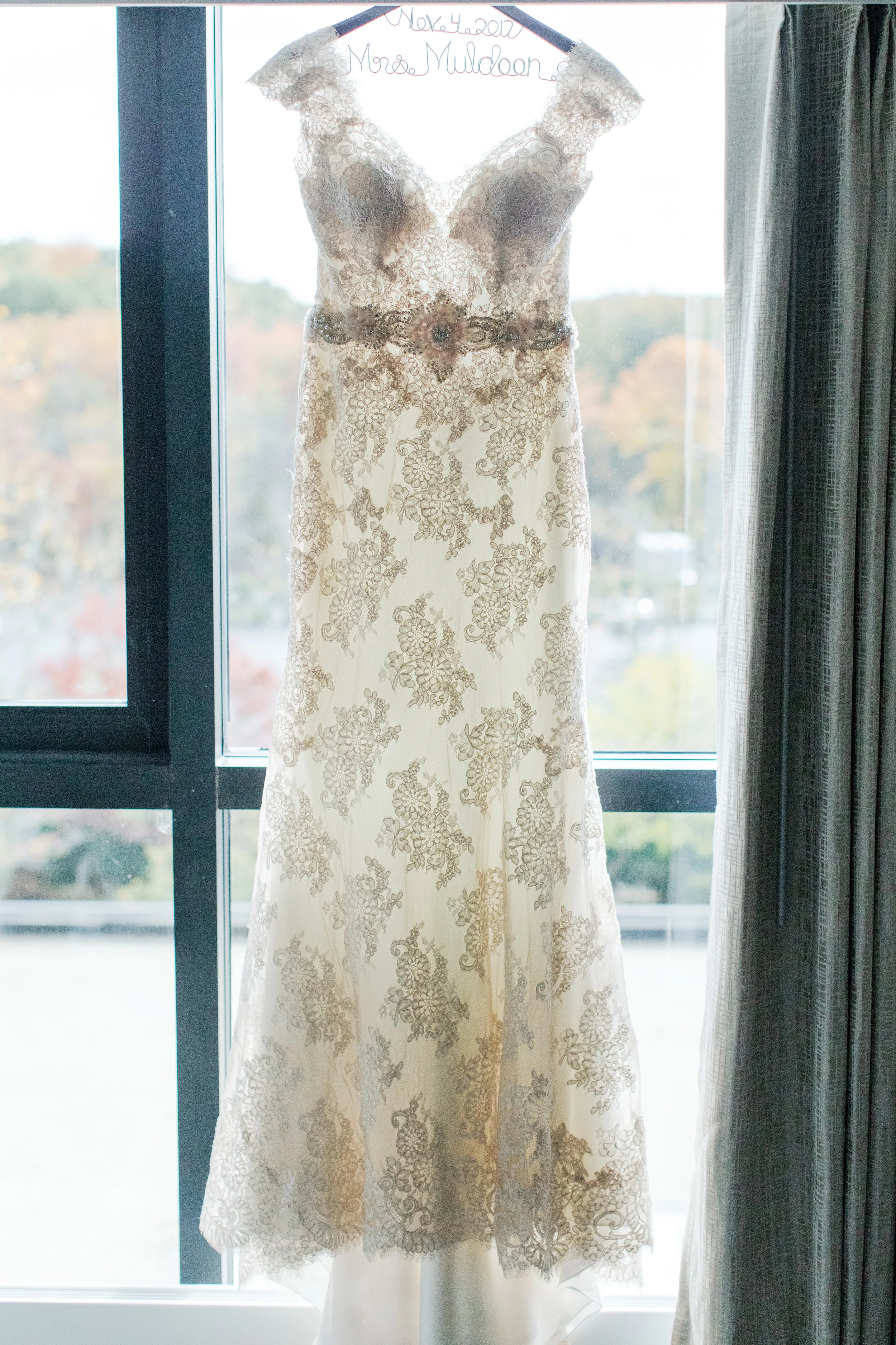 Fitted lace allure bridals wedding dress with beaded belt on mrs hanger photographed by jaye kogut