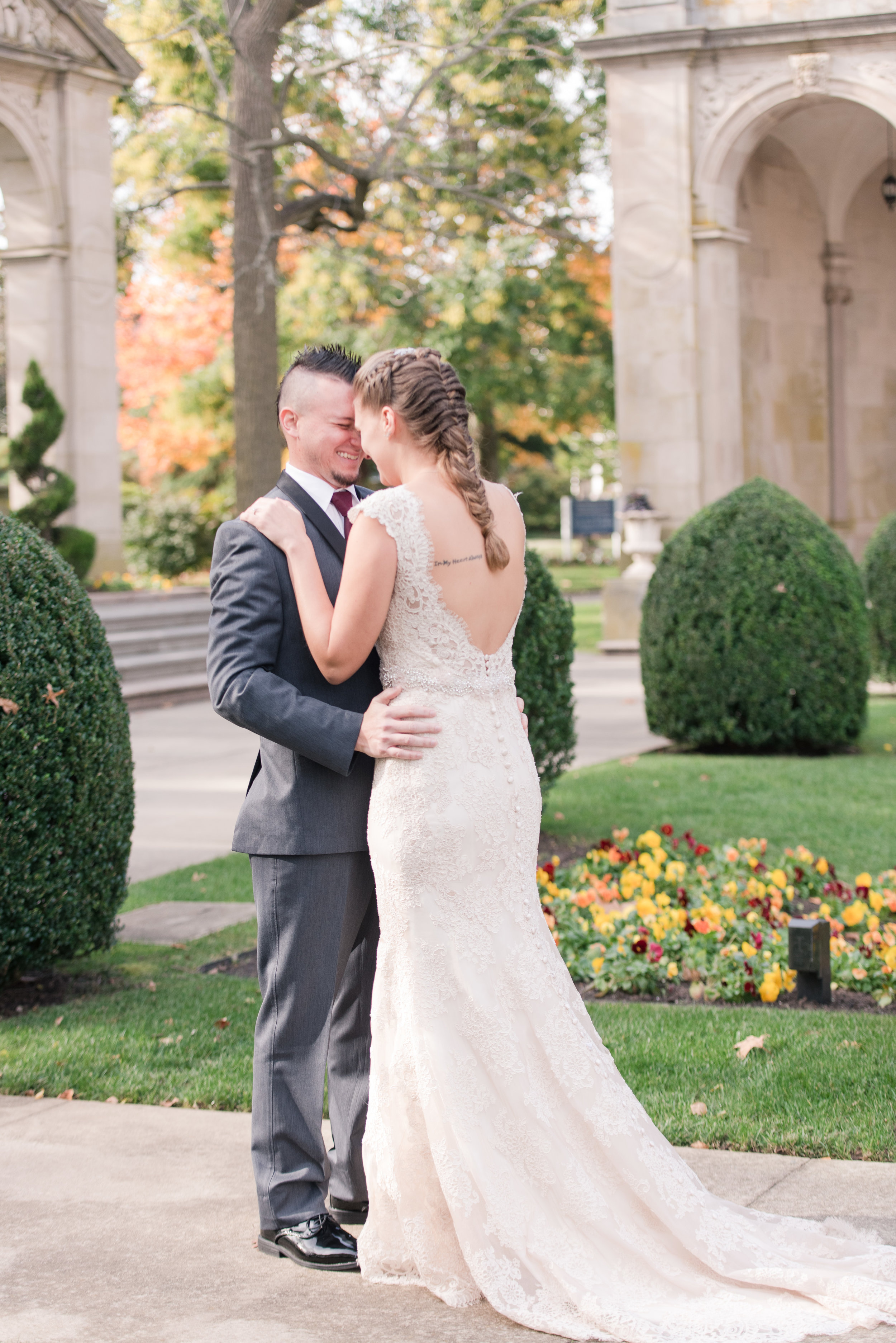 groom in dark gray suit at monmouth university sees bride in allure bridal lace wedding dress with low back and buttons for the first look