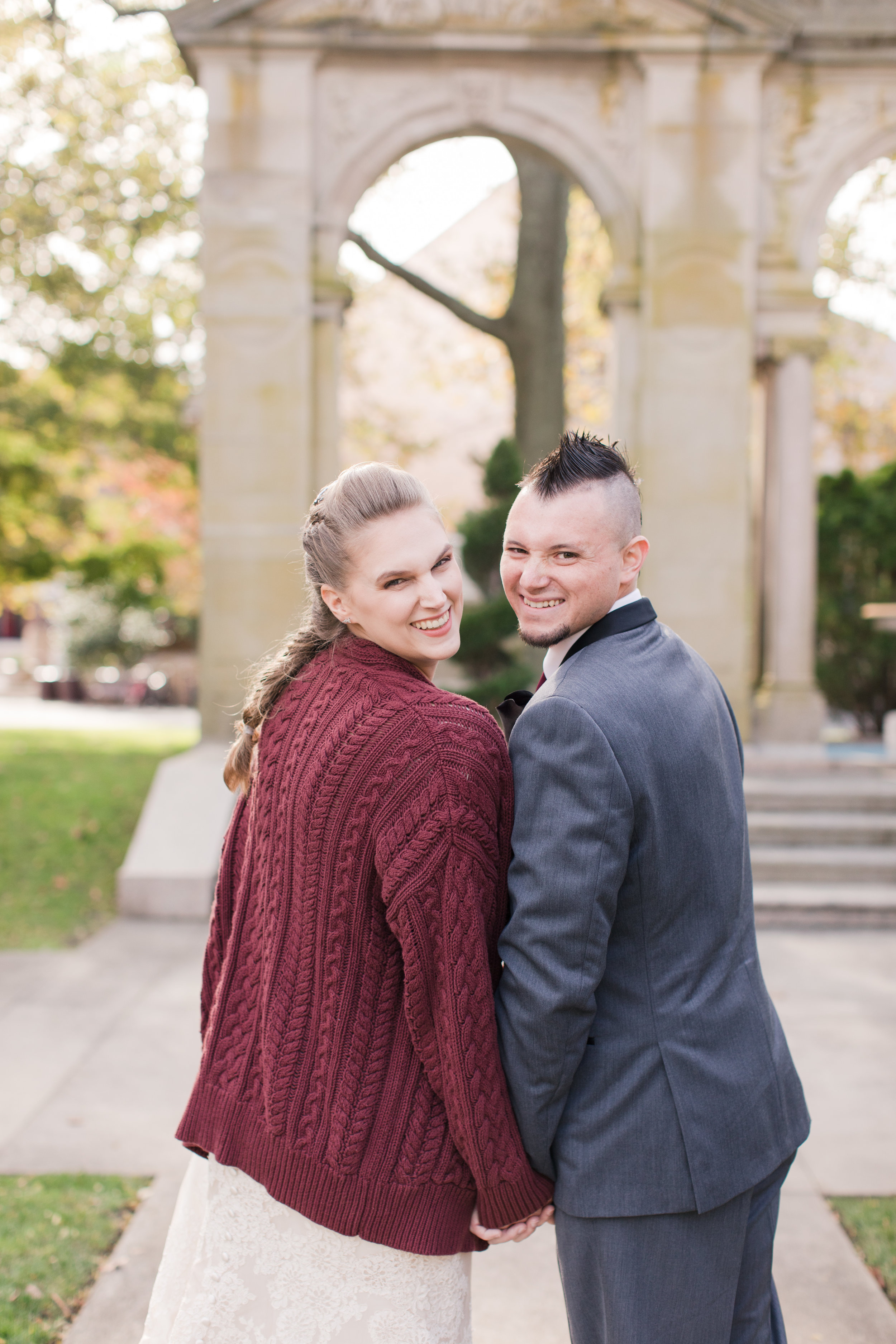 bride poses with groom in chunky knit sweater at fall new jersey wedding