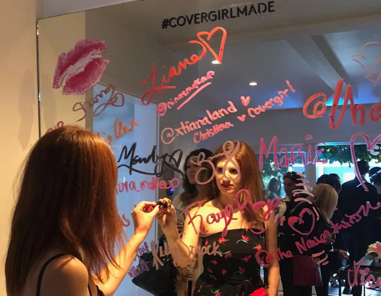 Signing my name to the Covergirl lipstick mirror!