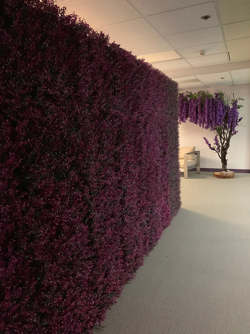 Guests are greeted by pretty faux trees and a shrub wall.