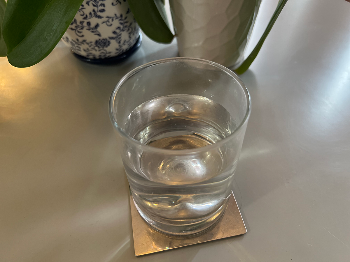 A glass of water on a silver coaster
