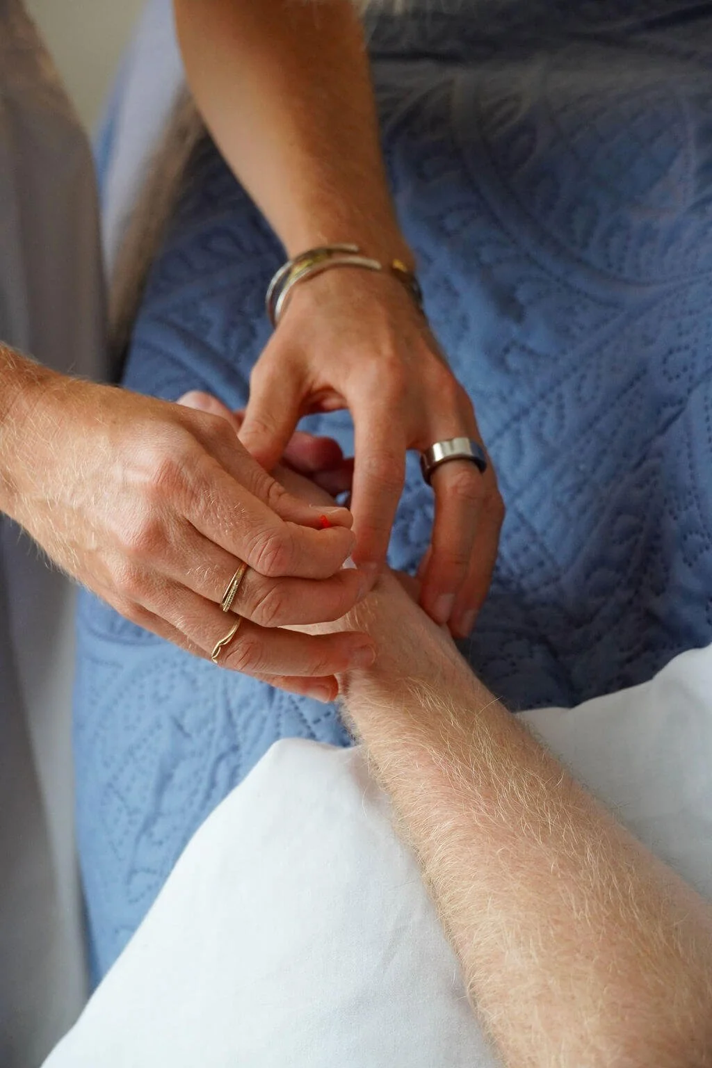 Acupuncturist inserting needle into man's arm during session at work in West Ashley, SC