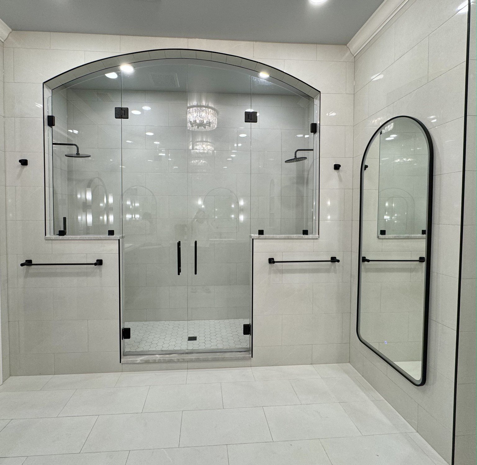 Large arched custom tile shower with glass enclosure completed by All Service Painting and Construction