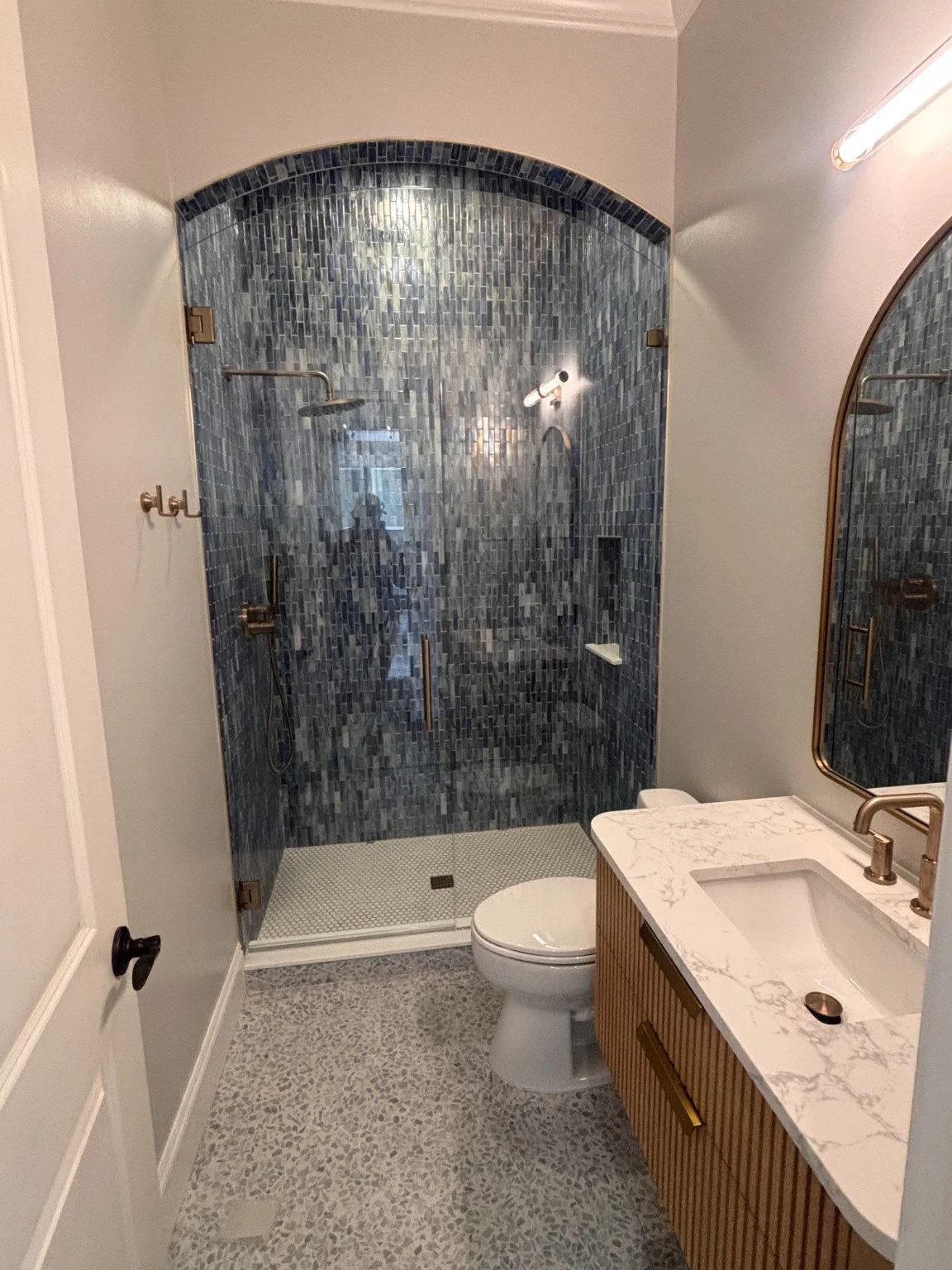 Blue arched custom tile shower and bathroom renovation completed by All Service Painting and Construction