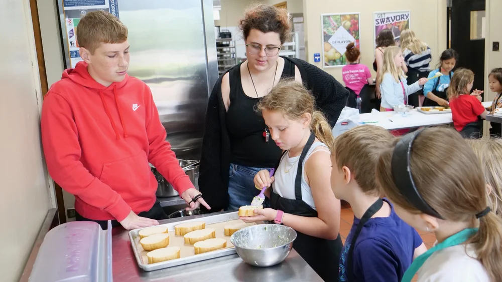 Campers preparing food together in a kitchen