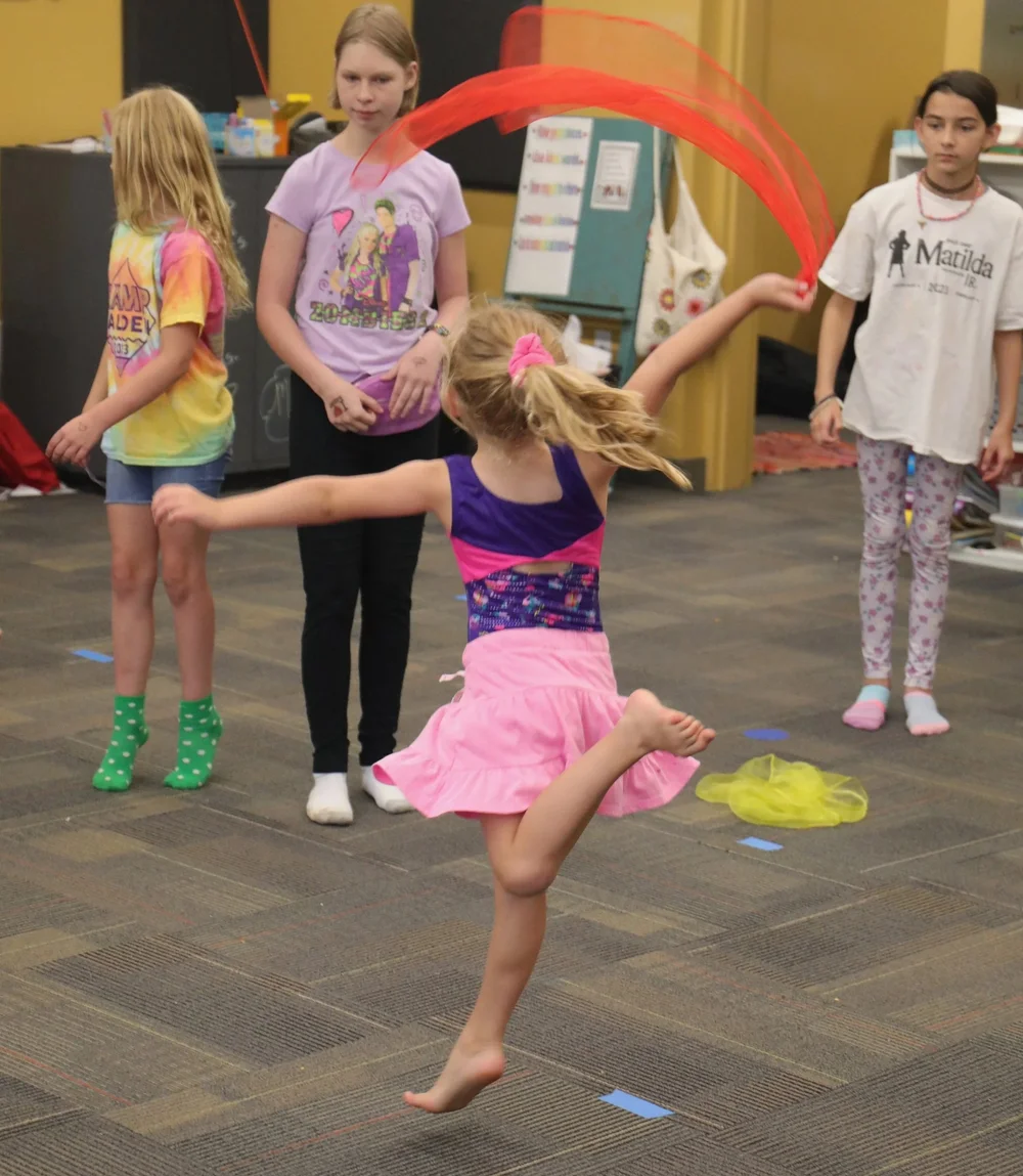 Camper practicing a dance routine with colorful ribbons