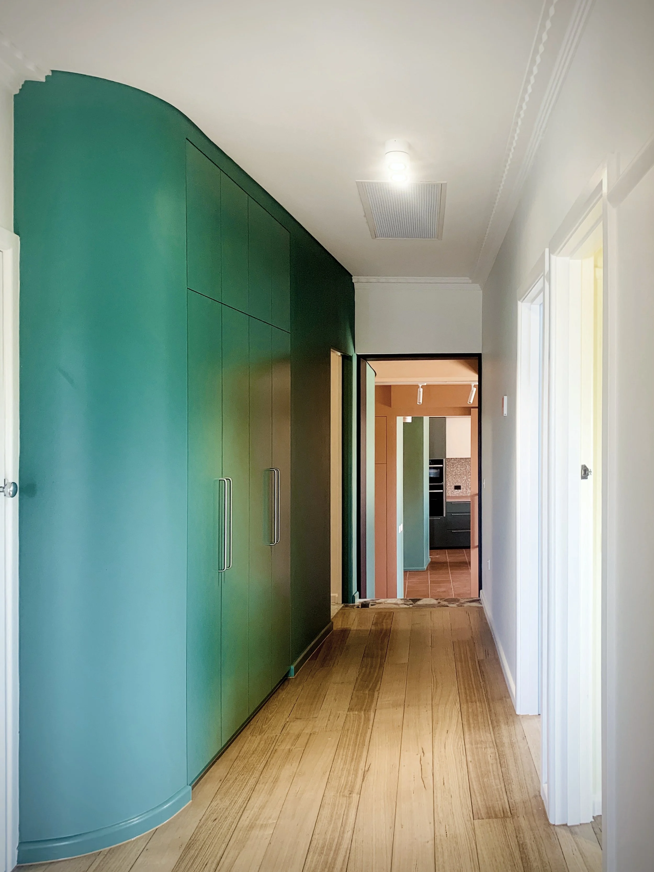 Bold green wall leading the way through from the front door to the new living room at the rear 