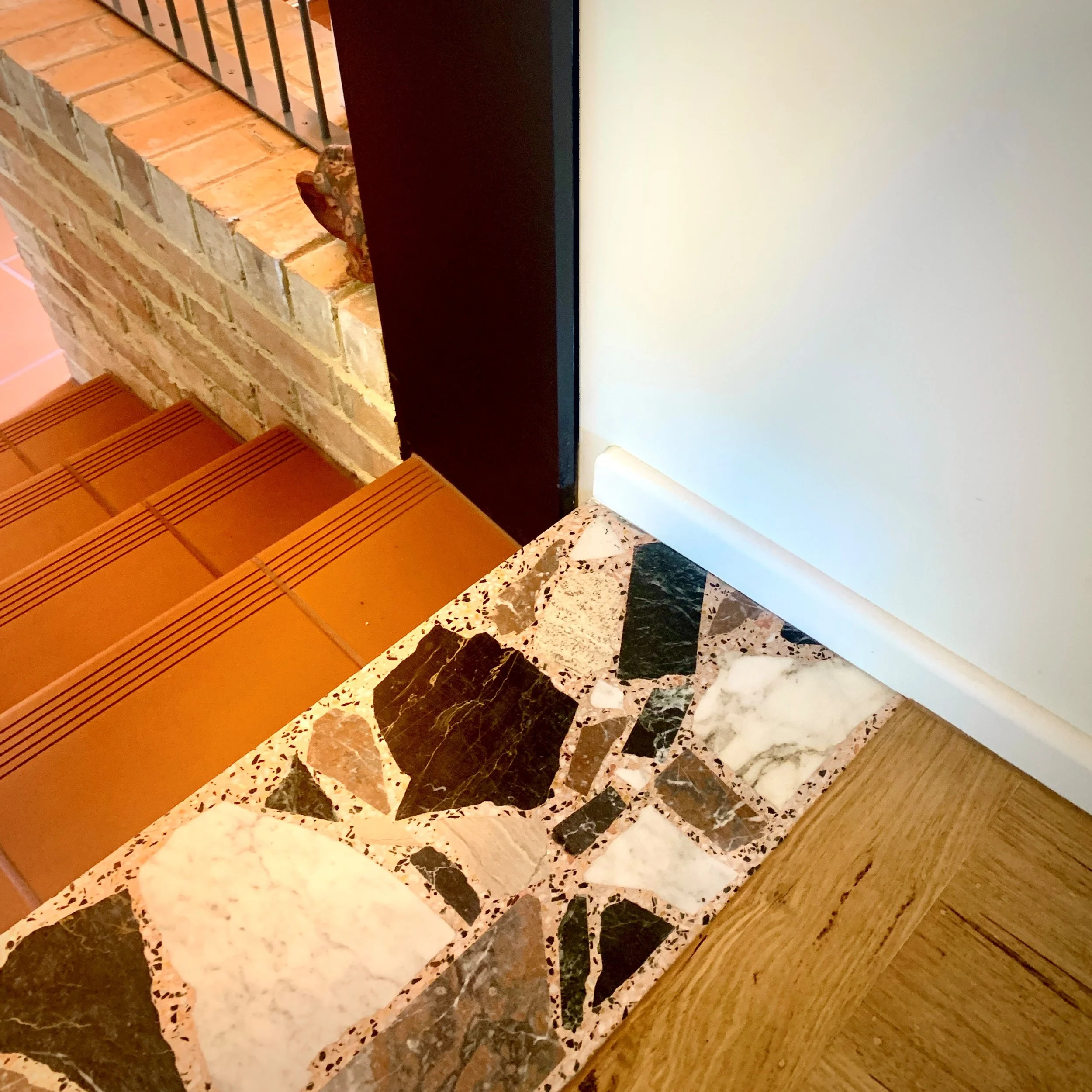 Repurposed terrazzo hearth at transition point between old and new