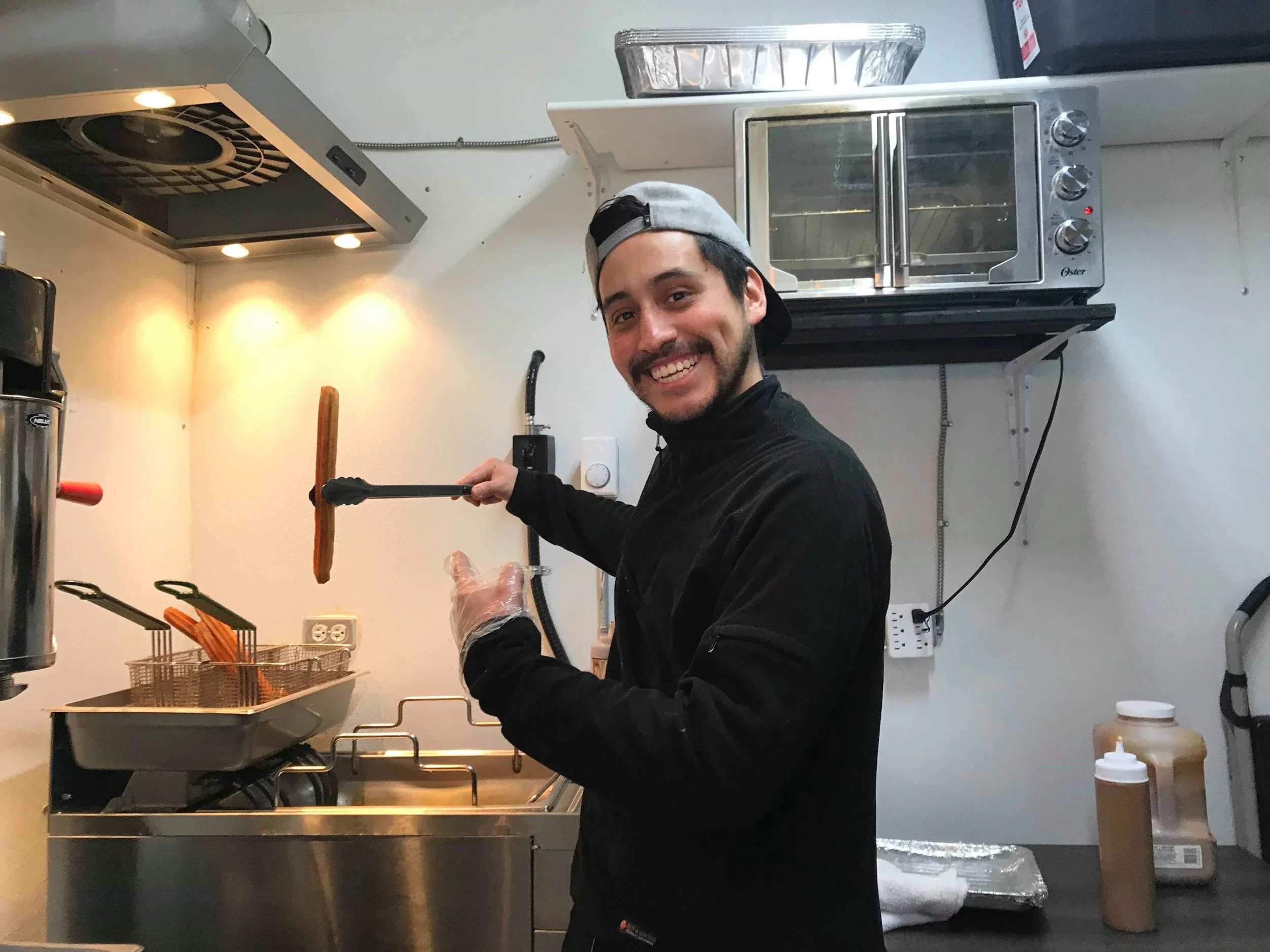 Sergio Herrera making fresh churros inside of the Choco Churros stand. (CanCulture/Keisha Balatbat)