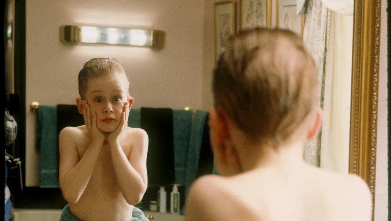 Kevin McCallister (Macaulay Culkin) trying aftershave for the first time in an iconic scene from the first Home Alone film from 1990. (Photo Courtesy: 20th Century Fox)