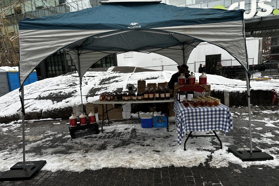  A vendor is organizing his tent with many maple-filled products, such as a Canadian favourite, maple syrup. (CanCulture/Aliya Karimjee) 