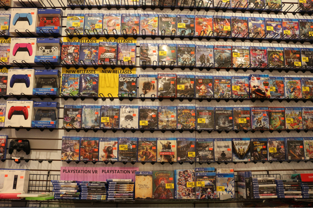  PS4 video game cases face forward on rows of shelving showing their covers. 