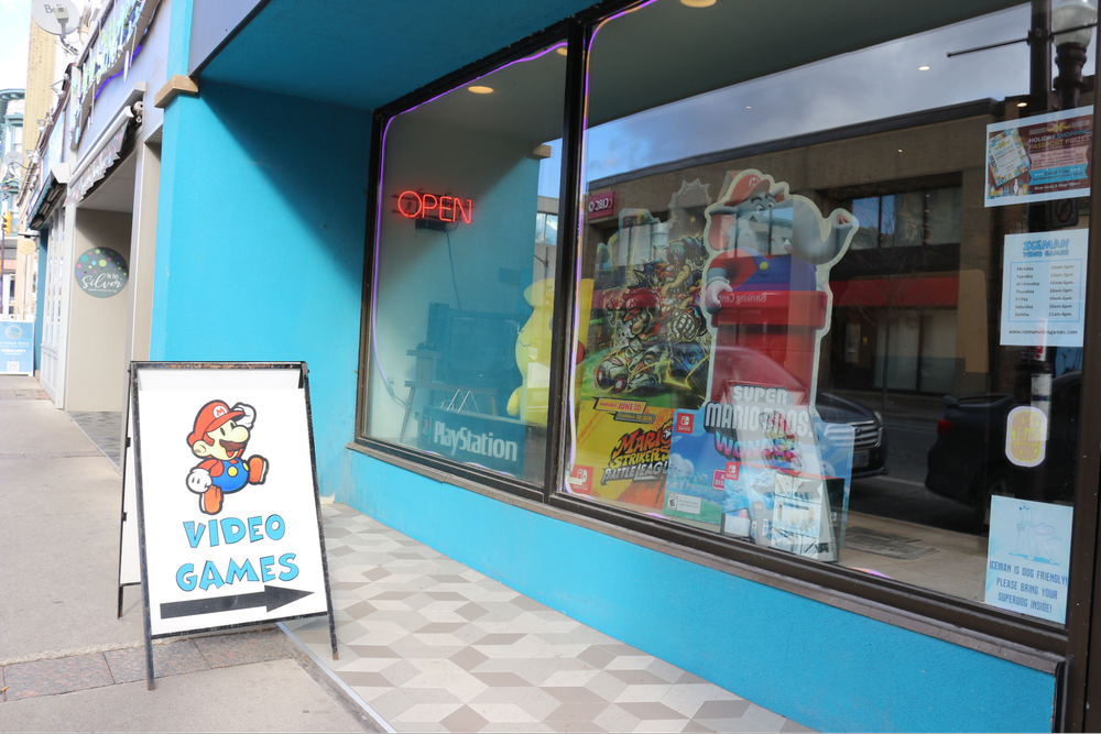  Iceman Video Games outdoor sign points towards the storefront. 