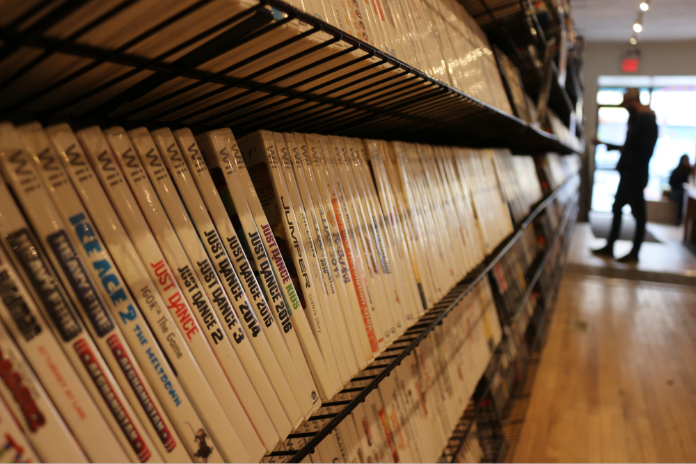  Close up of Wii game selections among other shelves filled with cases. 