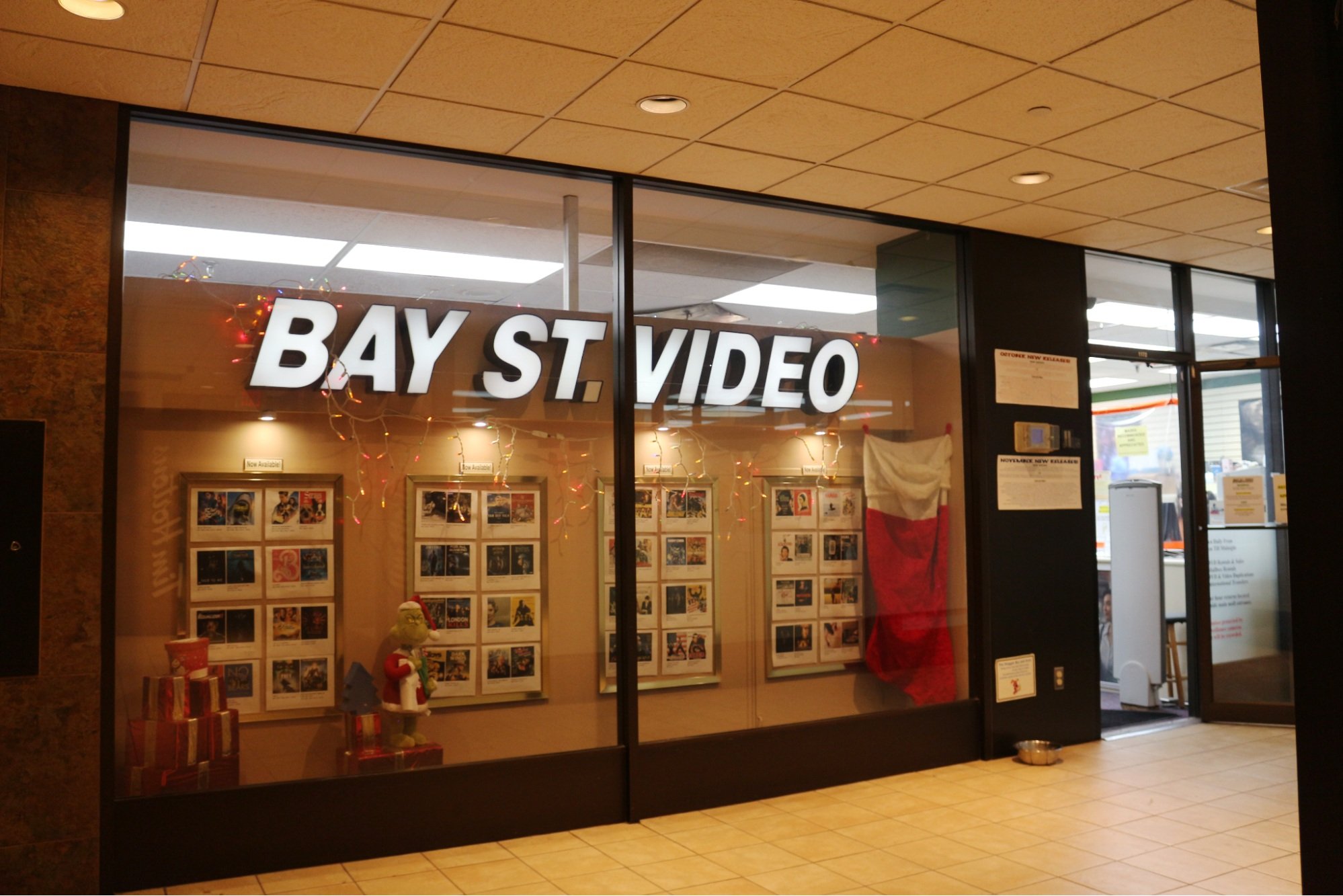 The Bay St Video window display is filled with Christmas decorations and movie posters. 
