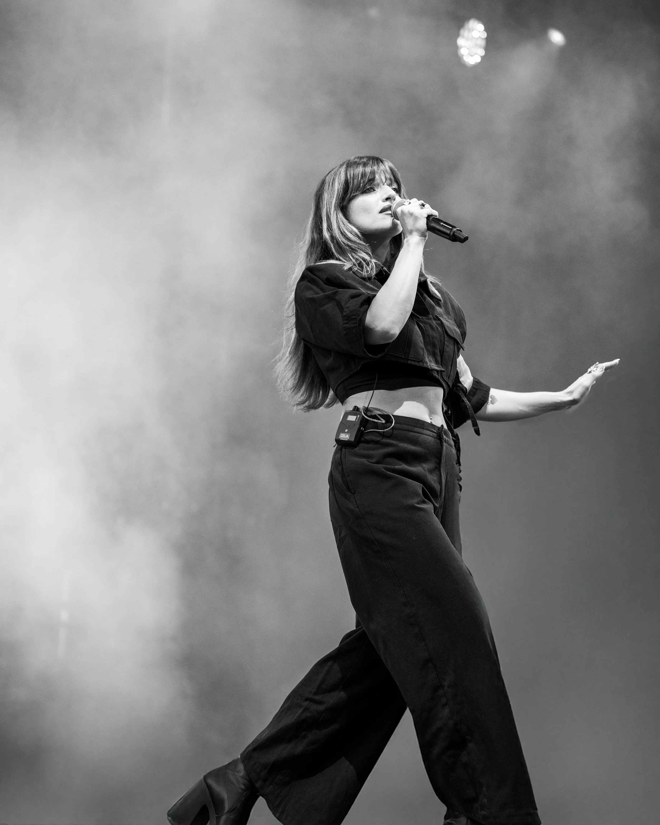 une femme chante sur scène, tenant un microphone, en noir et blanc