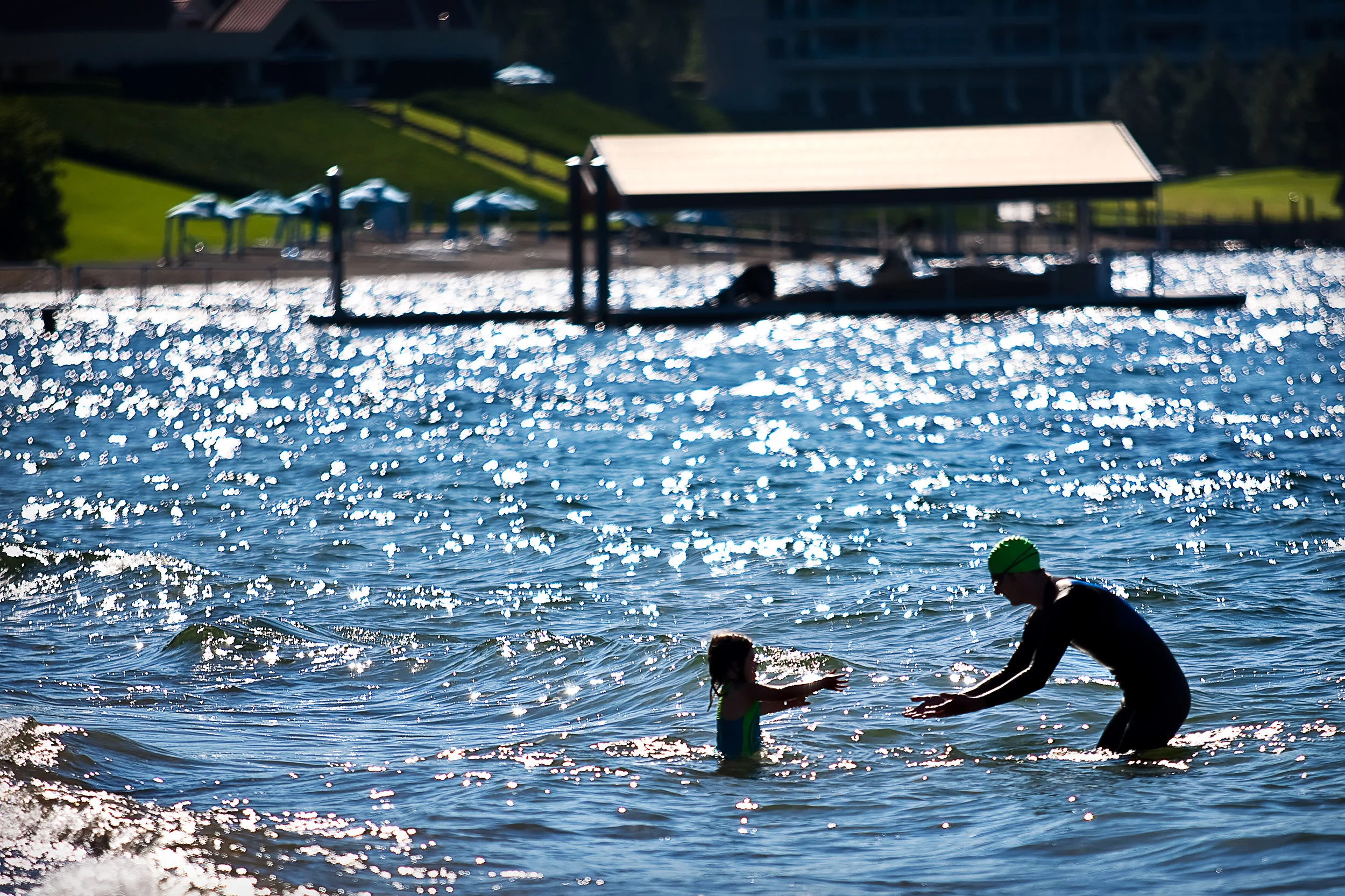 Marcos Donolo of Pullman reaches out to hold his daughter Kiara on Sanders Beach just before the Steve Omi Memorial Swim in Coeur d’Alene on July 18, 2009.
