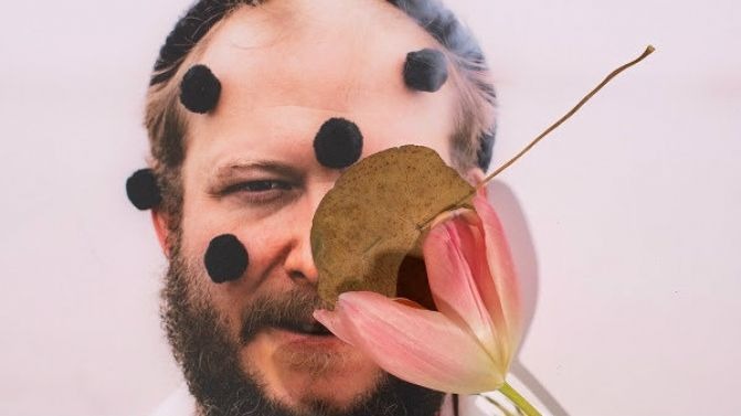 Justin Vernon, felicissimo di nascondersi dietro un fiore, una foglia e dei pon pon neri