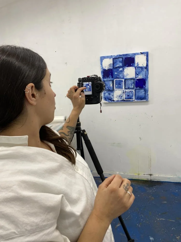  Photographer Stephanie Artuso using a tripod-mounted camera to document a multicoloured grid painting in Deb Chaney's studio. 