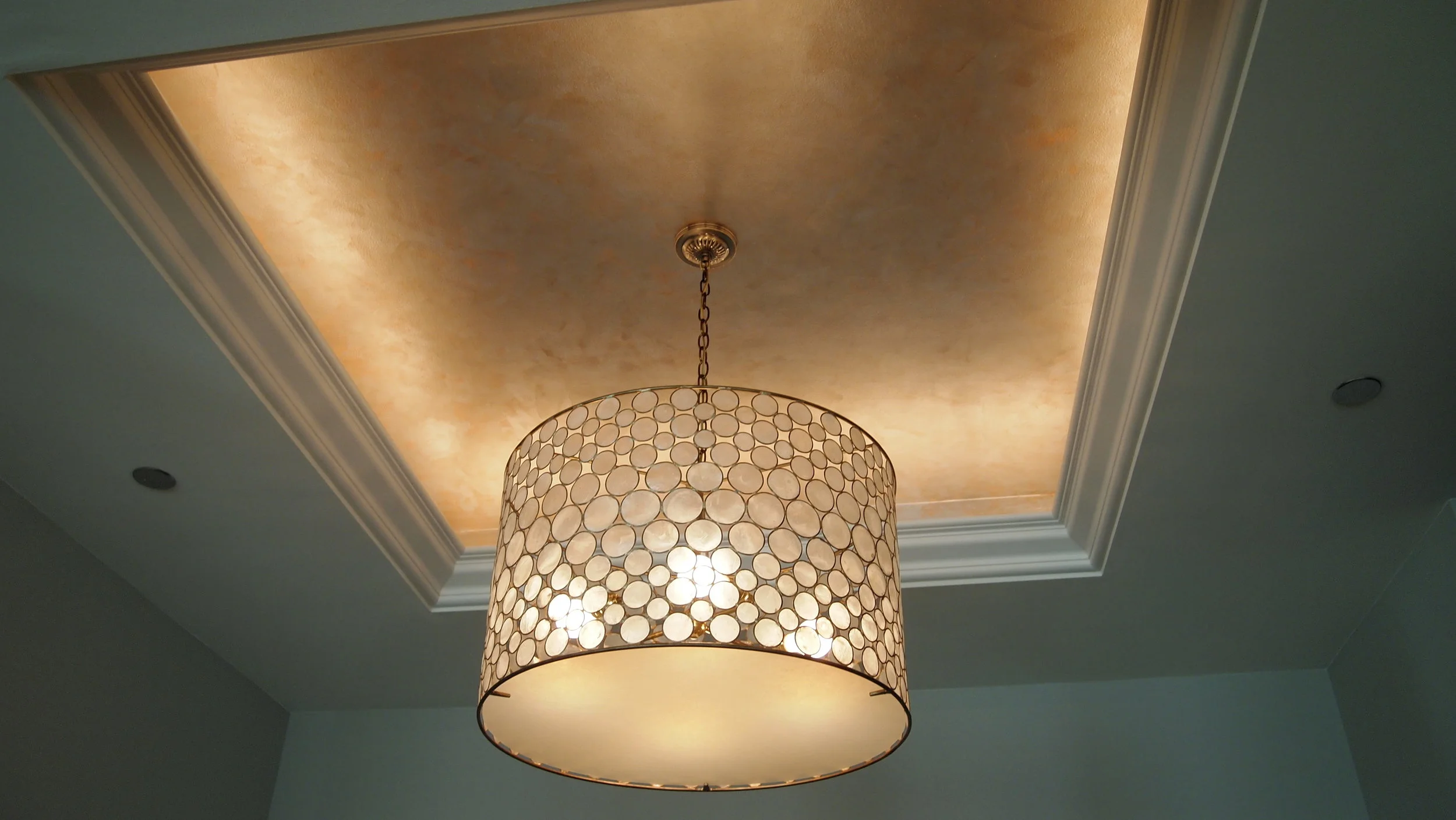  To achieve a classic look I used a combination of two metallic colors here. This ceiling cove creates a luxurious backdrop for the pendant extending far below surface of the ceiling.&nbsp;Lighting hidden along perimeter of the trim adds to the glowi