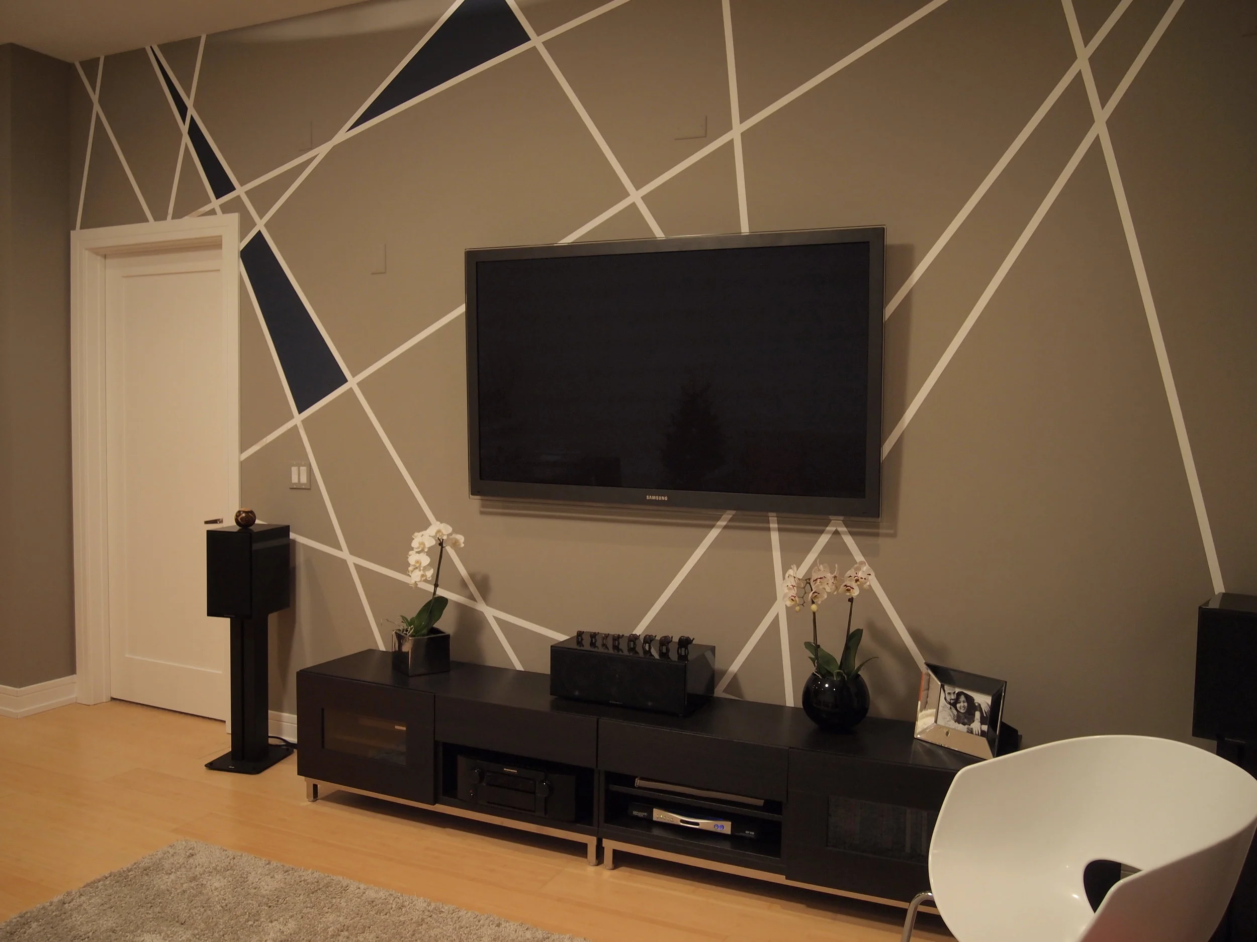  This design is complex disguised as simple. Its shapes come in the door and relax as they move into the room. Graphic lines break up the wall and give it a sense of dimension.&nbsp;Filling a few of the shapes with a complementary hue adds some balan