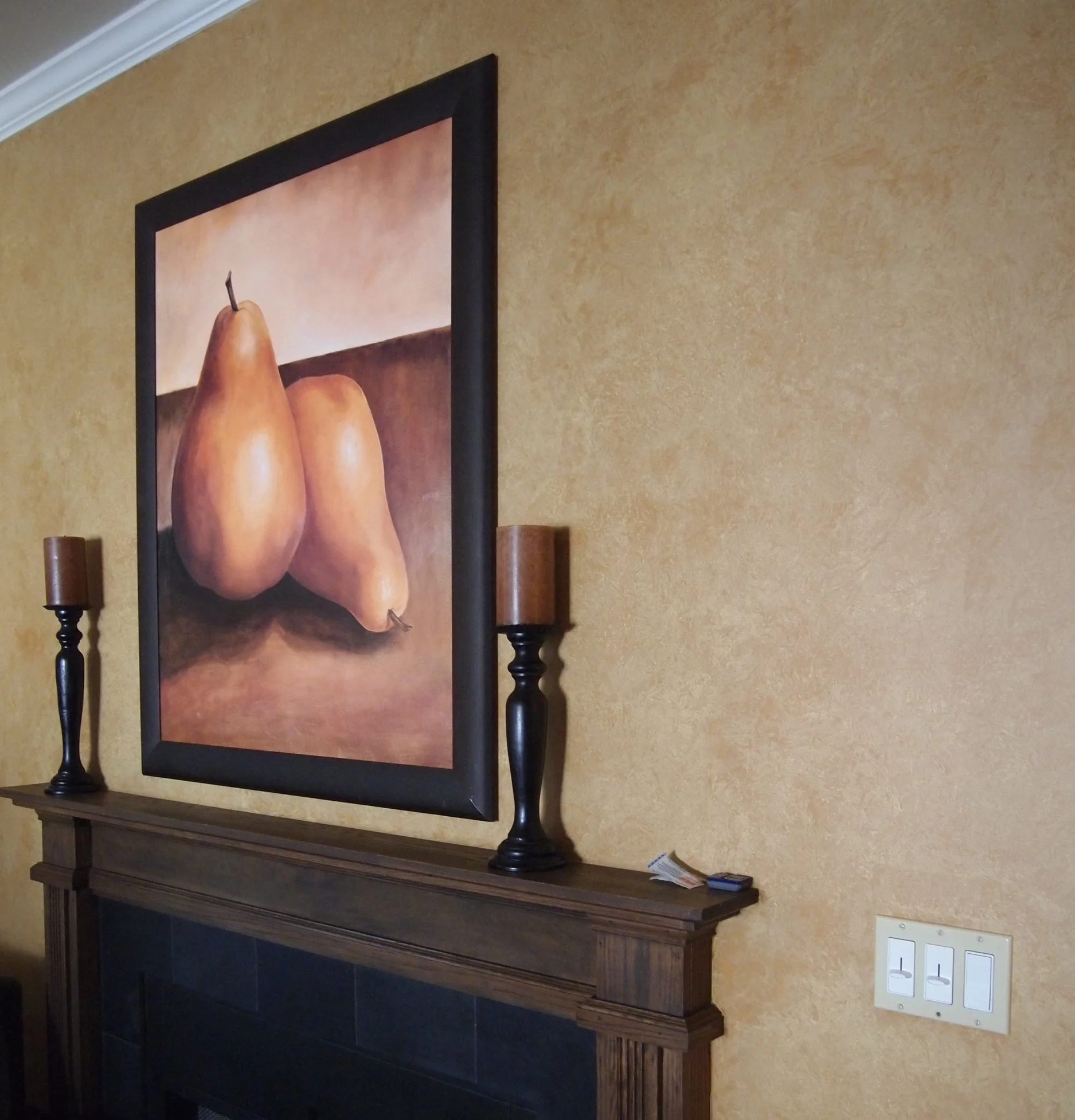  Intended to be a focal point and separation between two parts of the house, the fireplace wall was covered in rag-off technique using darker tones of the wall color. The size of the fireplace commands attention. The use of toned-down yellow blends i