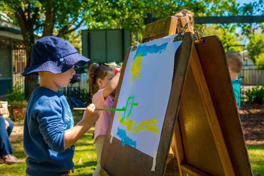 Boy painting on old wooden easel in Chiselhursts front garden