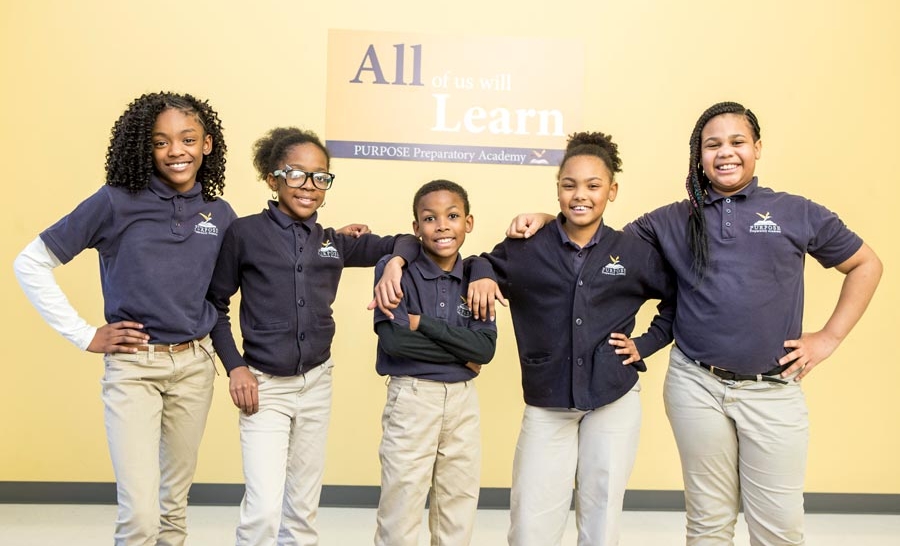 Smiling students posing for a photo in the hallway.